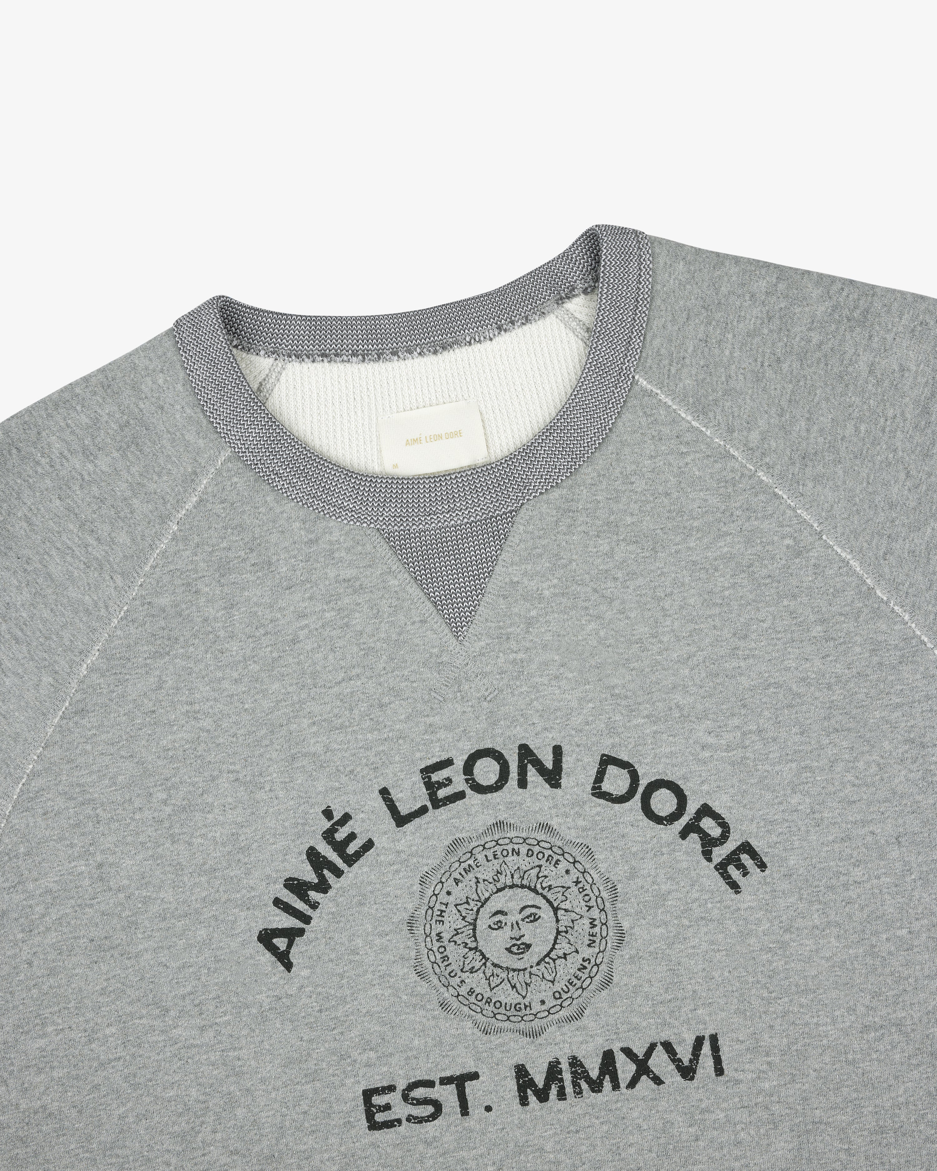 Souvenir Crewneck Sweatshirt in gray with Aimé Leon Dore EST. MMXVI and sun graphic on the front.