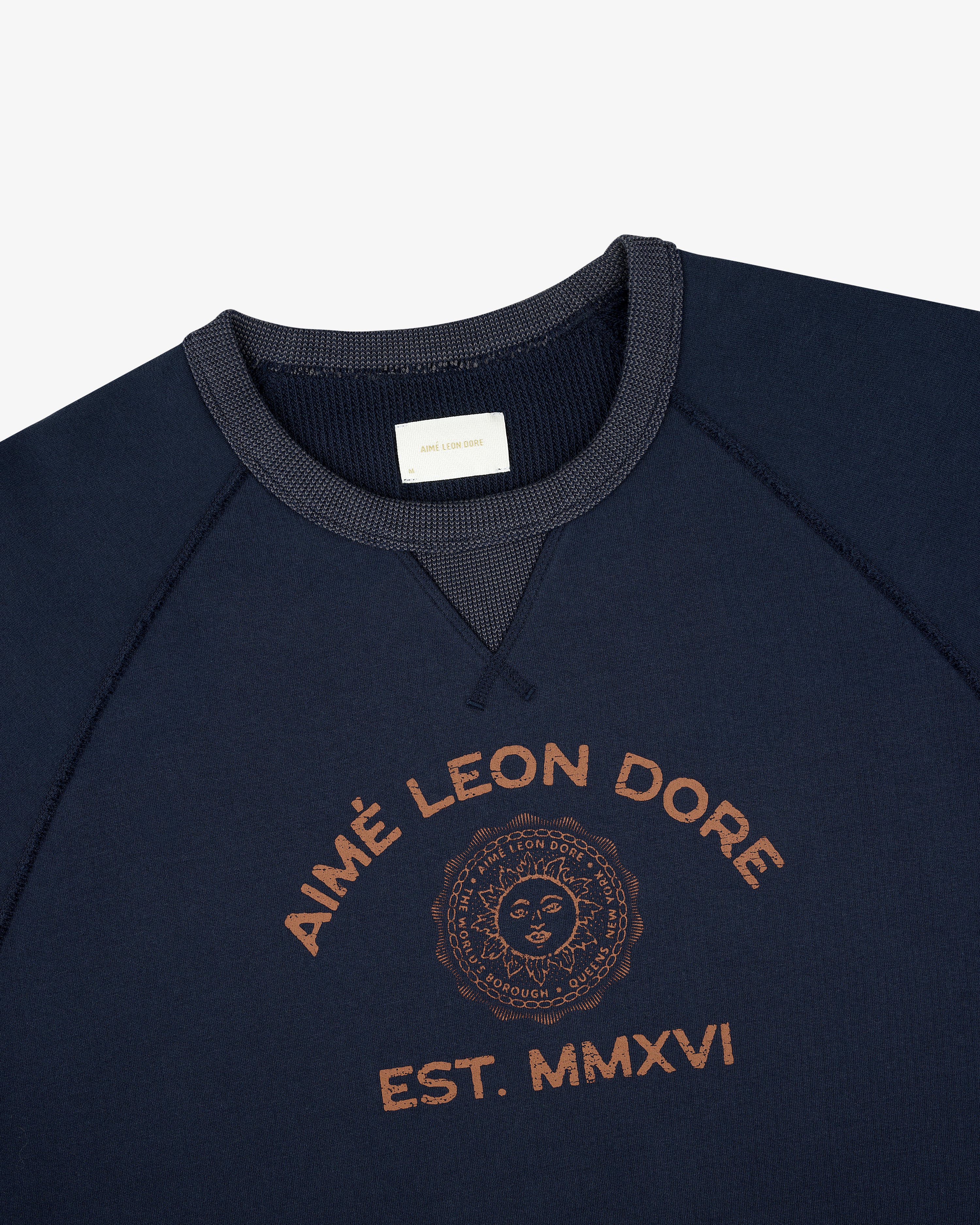 Souvenir Crewneck Sweatshirt in navy with brown Aimé Leon Dore EST. MMXVI and sun emblem printed on chest.