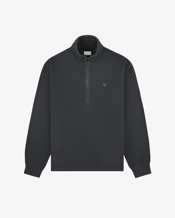 Crest Piqué Half-Zip Pullover in dark gray with a small left chest logo, shown on a plain white background.