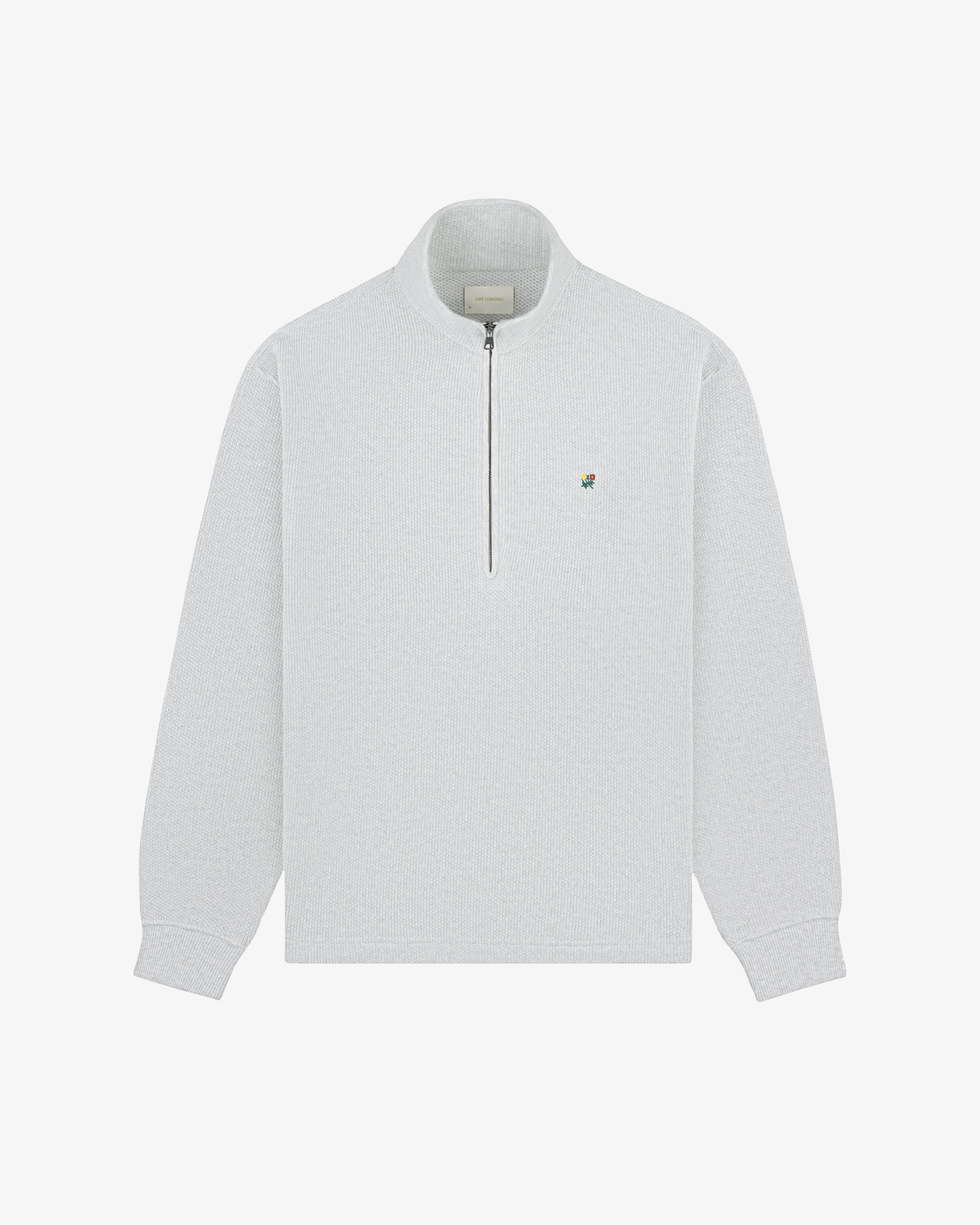 Light gray Crest Piqué Half-Zip Pullover with small embroidered logo on left chest, laid flat on white background.