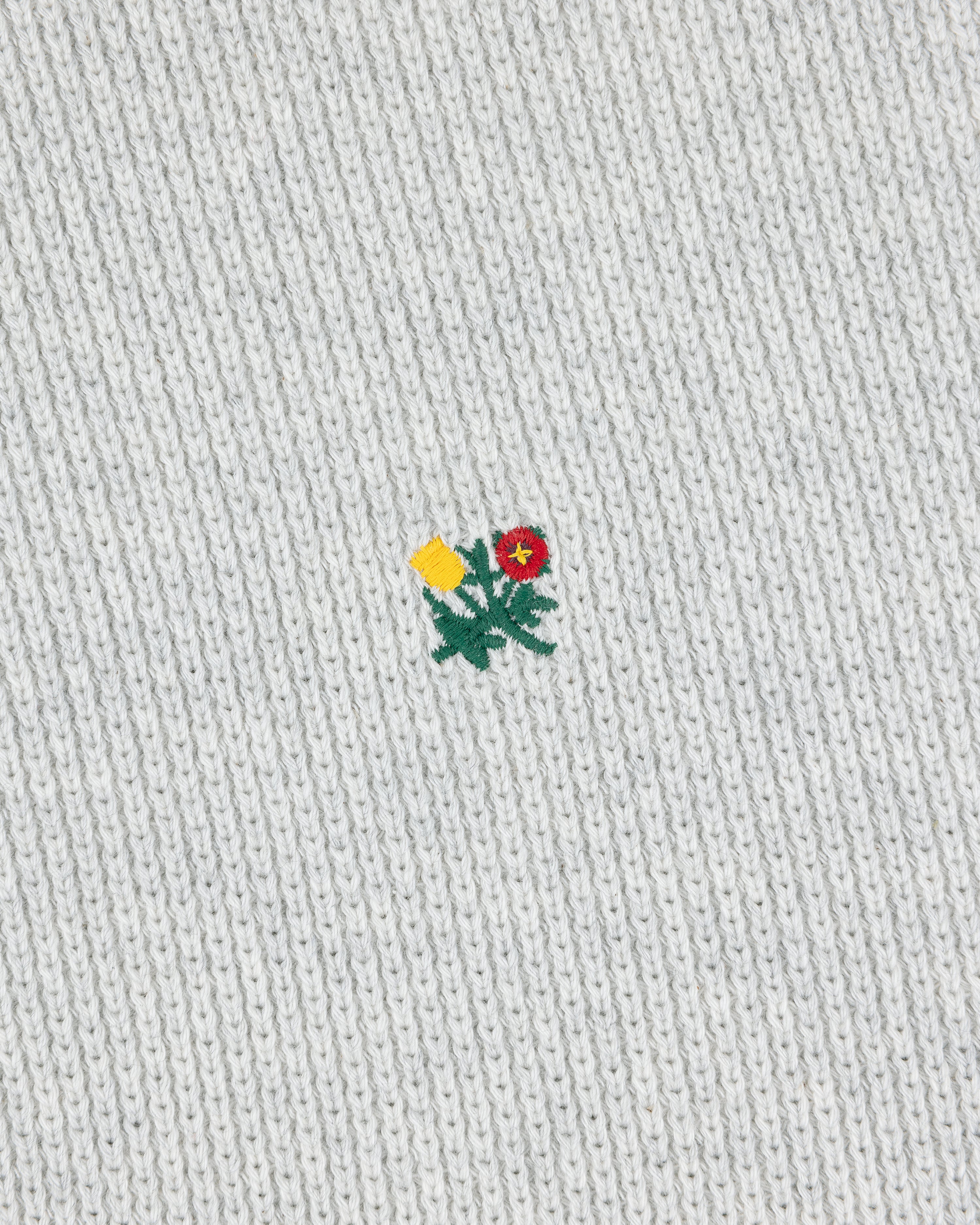 Small yellow and red embroidered flower on the light grey Crest Piqué Half-Zip Pullover.
