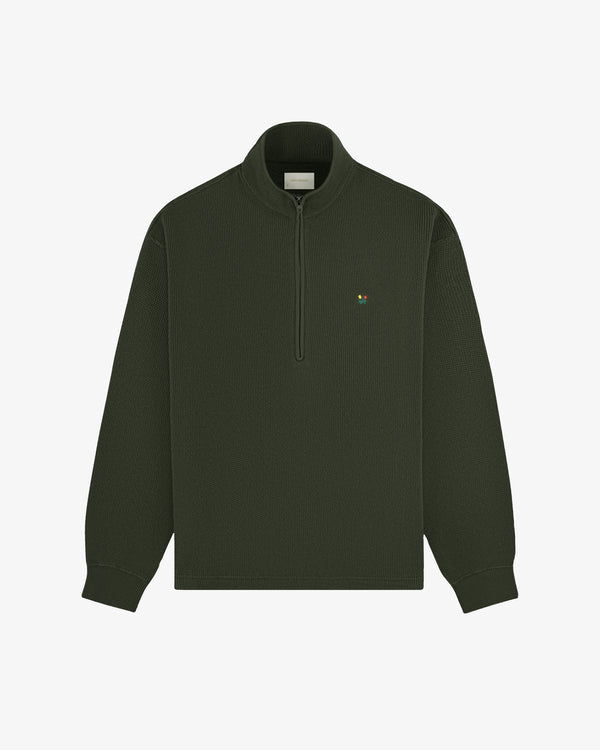Crest Piqué Half-Zip Pullover in dark green with long sleeves and a small embroidered chest logo.