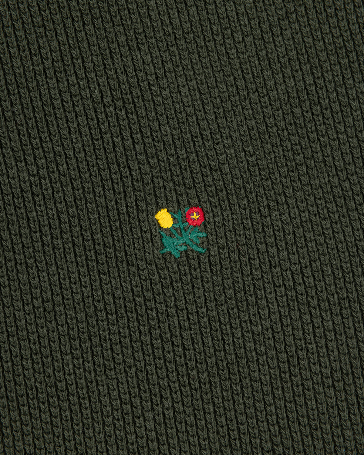 Dark green Crest Piqué Half-Zip Pullover with ribbed fabric and small embroidered yellow and red flowers in the center.