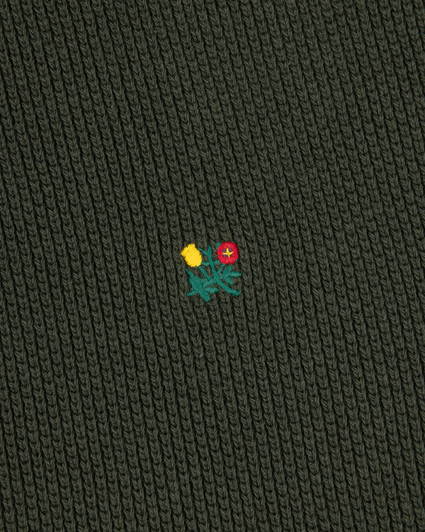 Dark green Crest Piqué Half-Zip Pullover with ribbed fabric and small embroidered yellow and red flowers in the center.