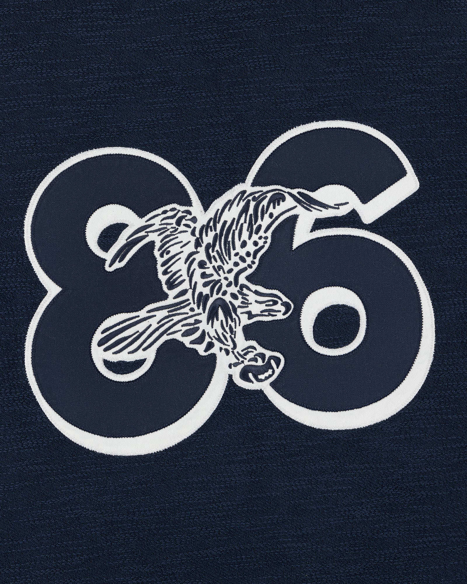 White eagle graphic over bold 86 on dark blue Legacy Slub Football Jersey.