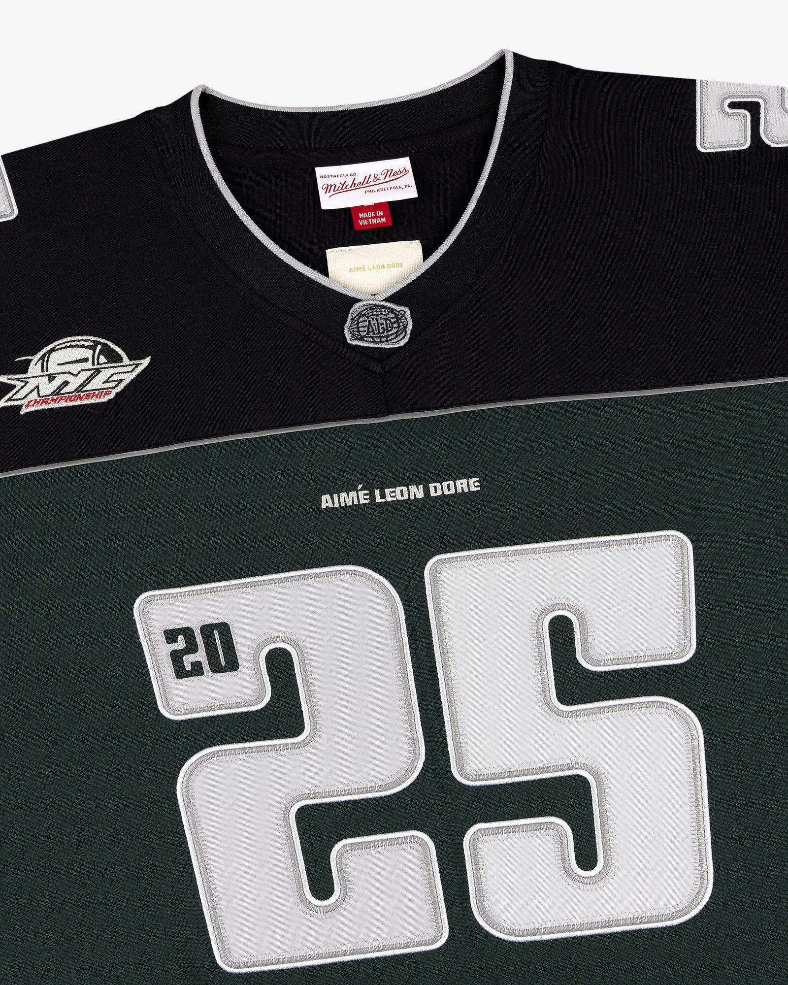 Close-up of a black and green ALD / Mitchell & Ness Football Jersey with number 25 and AIMÉ LEON DORE on front.