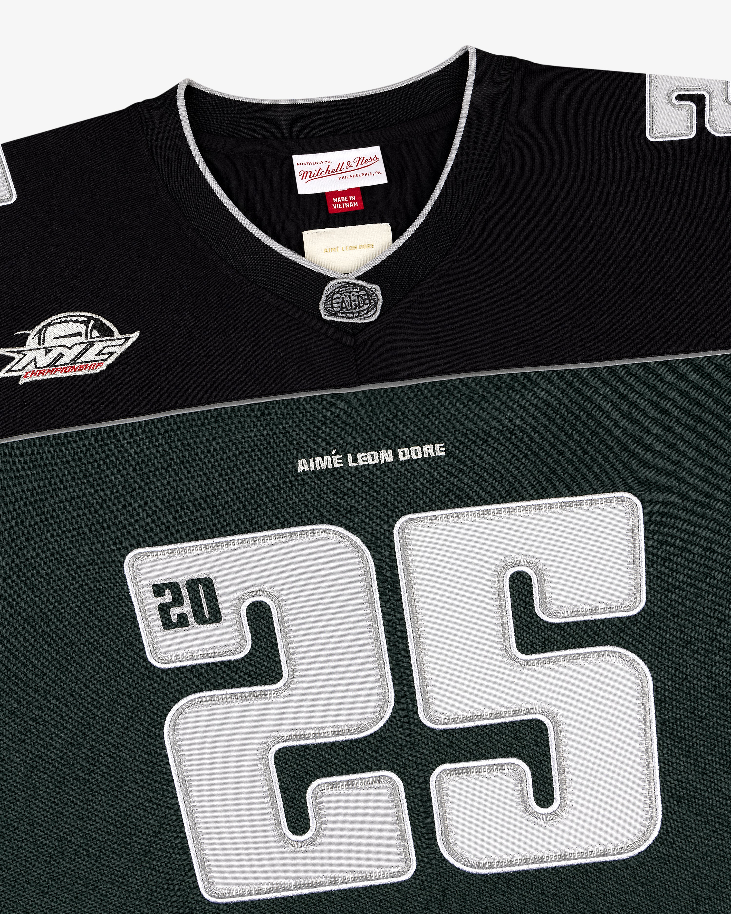 Close-up of a black and green ALD / Mitchell & Ness Football Jersey with number 25 and AIMÉ LEON DORE on front.