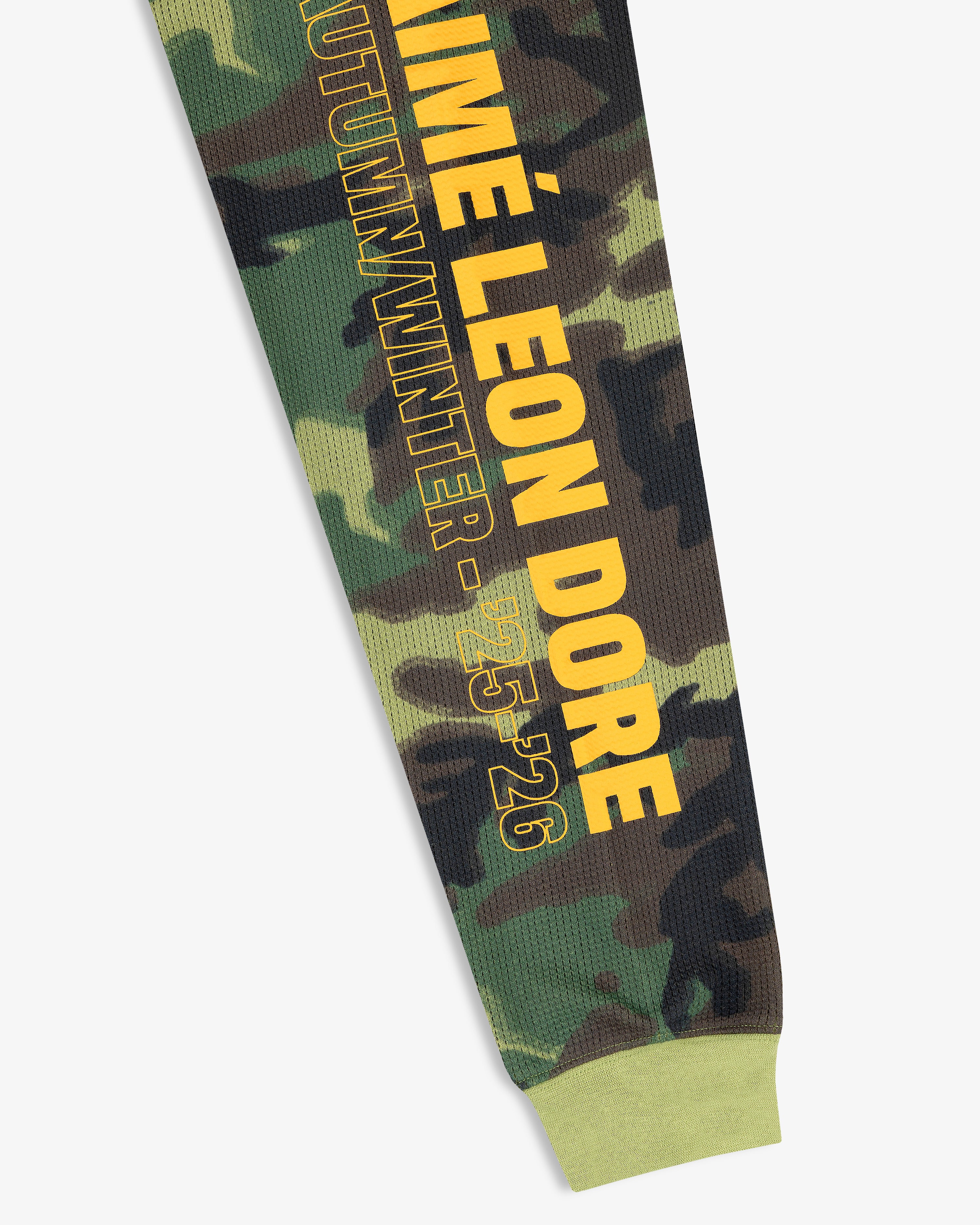 Printed Mesh Moto Tee: camo sleeve with yellow AIMÉ LEON DORE AUTUMN/WINTER 25-26 text and green cuff.