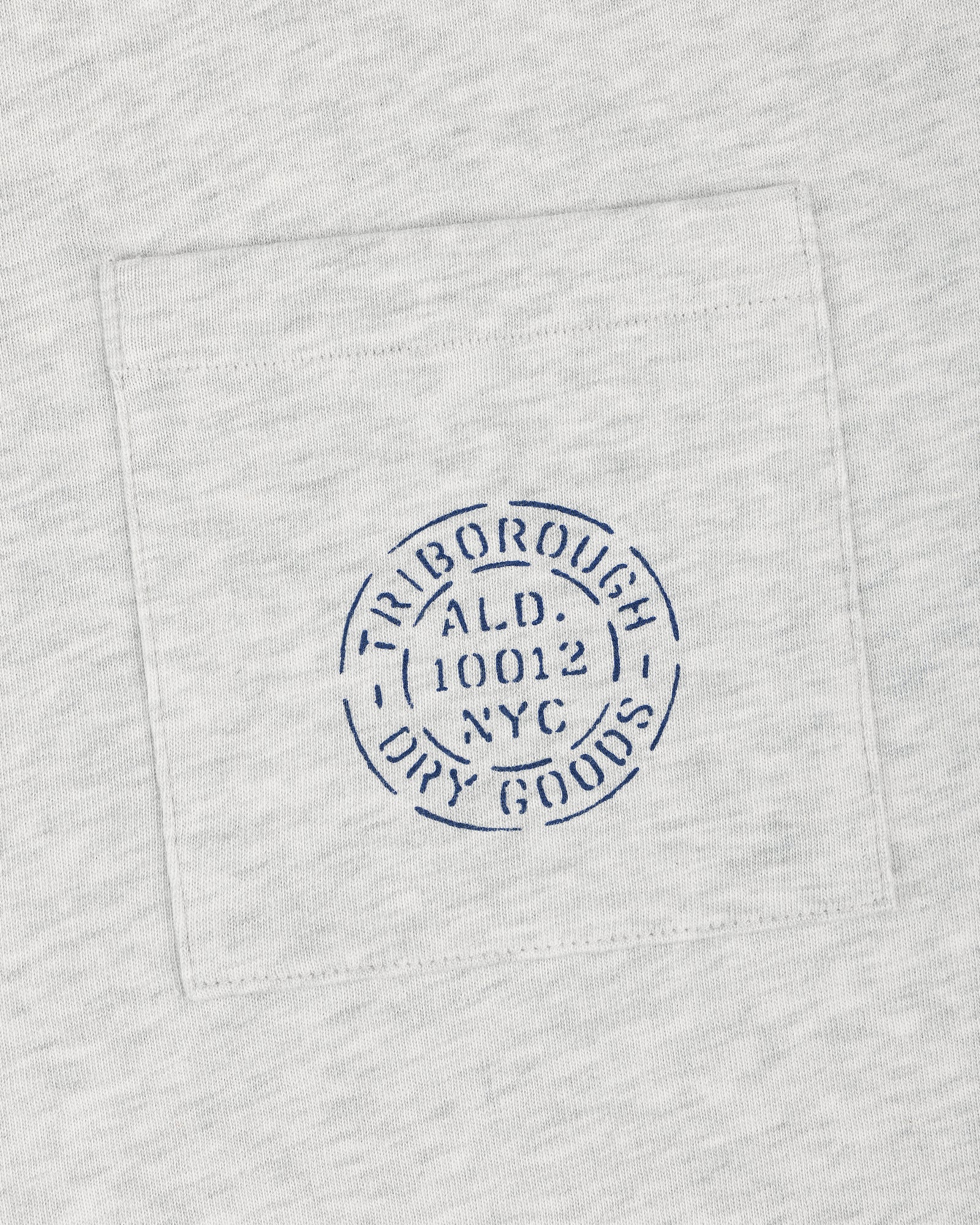 Light gray Triborough Dry Goods Pocket Tee with a blue circular TRIBOROUGH DRY GOODS ALD 10012 NYC stamp.