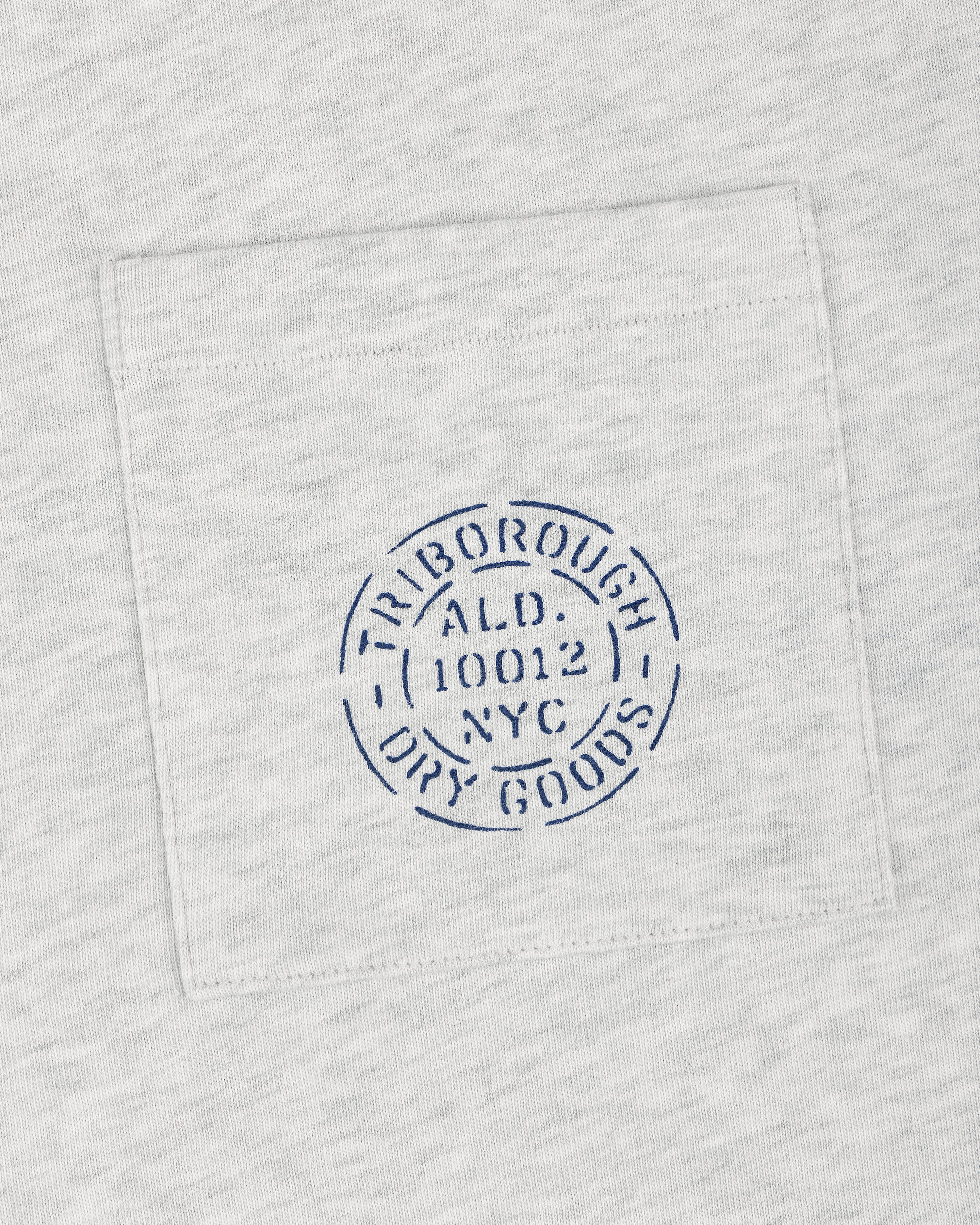 Light gray Triborough Dry Goods Pocket Tee with a blue circular TRIBOROUGH DRY GOODS ALD 10012 NYC stamp.