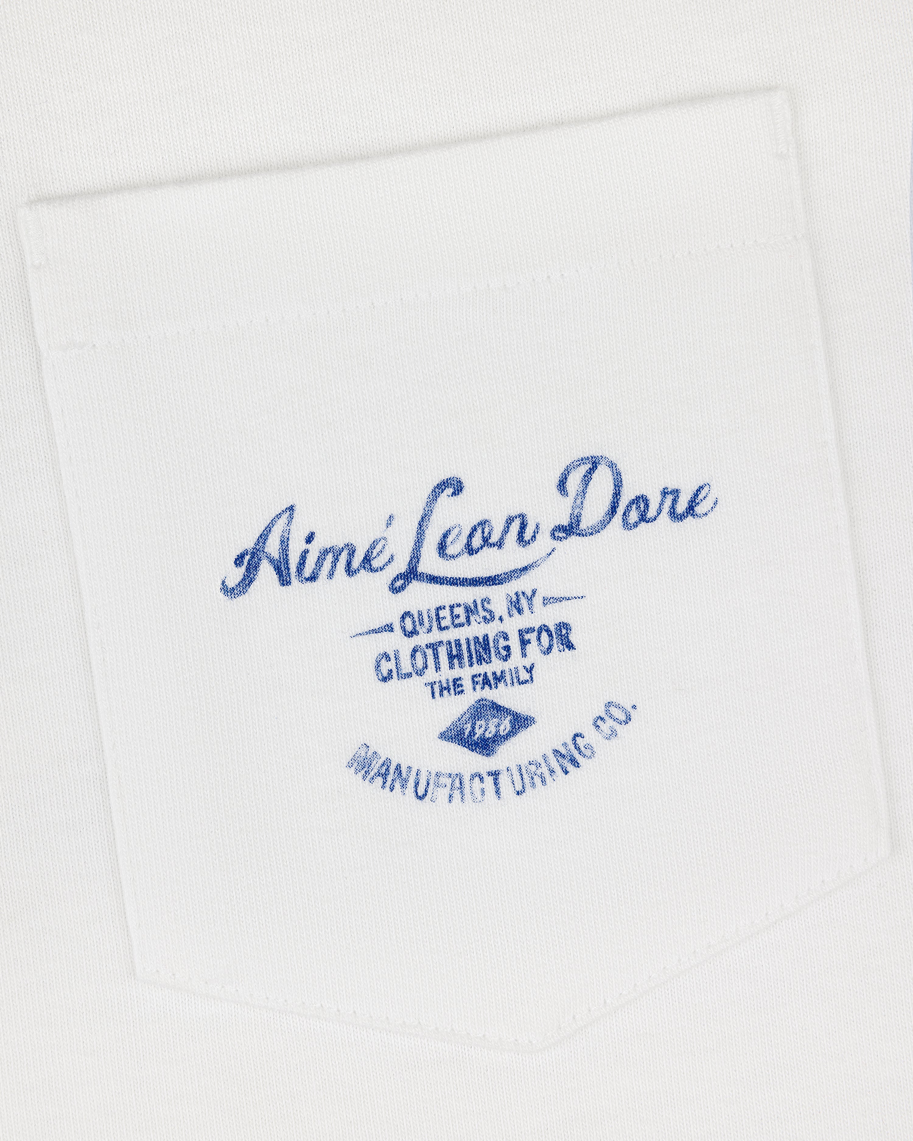 General Store Pocket Tee: White shirt pocket with blue text—Aimé Leon Dore, Queens, NY, Clothing for the Family.