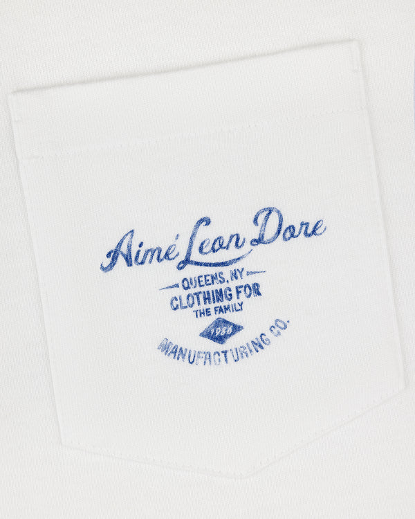 General Store Pocket Tee: White shirt pocket with blue text—Aimé Leon Dore, Queens, NY, Clothing for the Family.