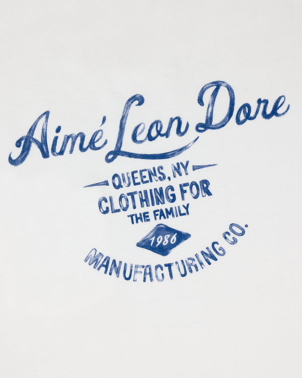 Blue script text reads General Store Pocket Tee on white fabric.