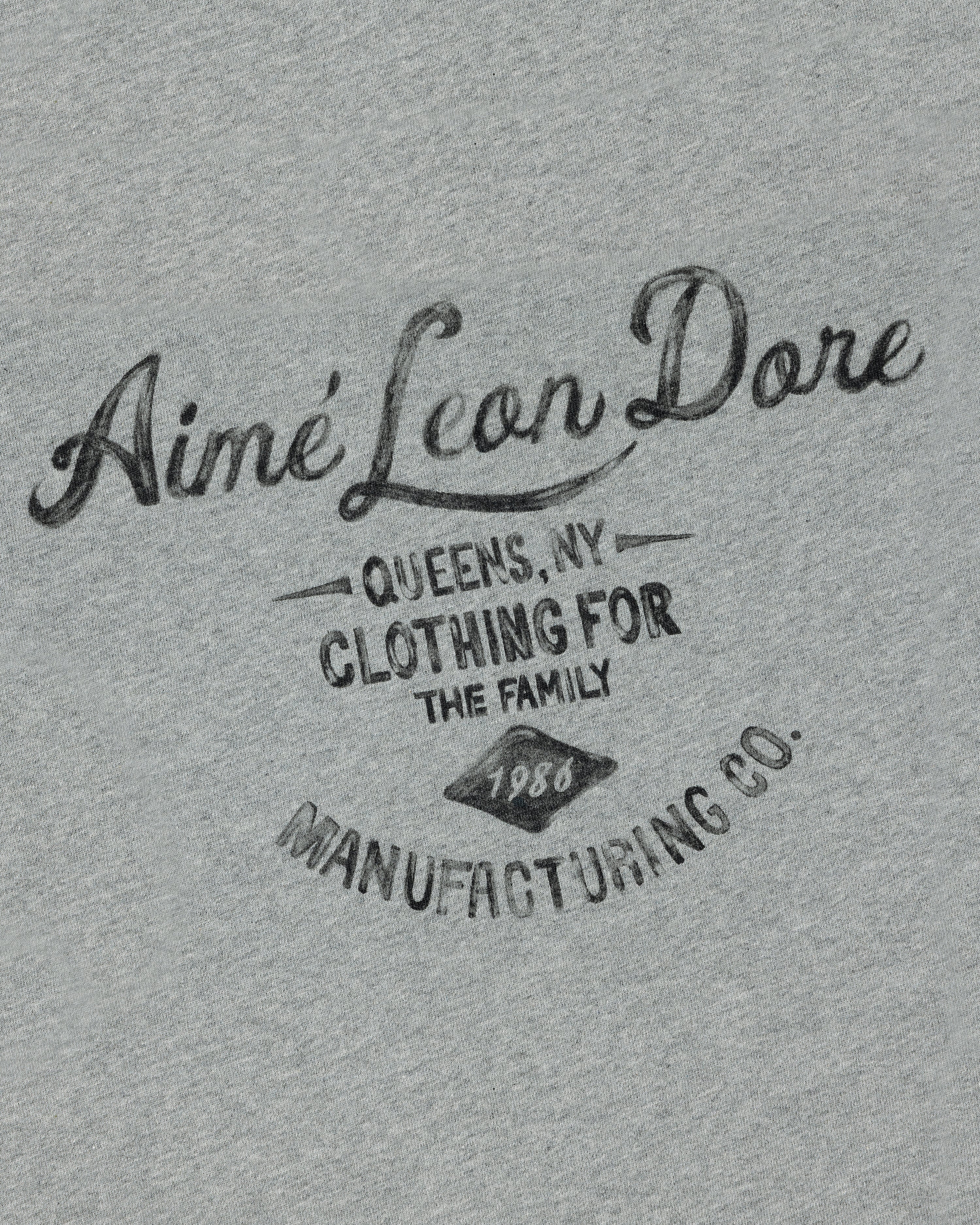 Gray General Store Pocket Tee with "Aimé Leon Dore Queens, NY Clothing for the Family 1980 Manufacturing Co." in black text.
