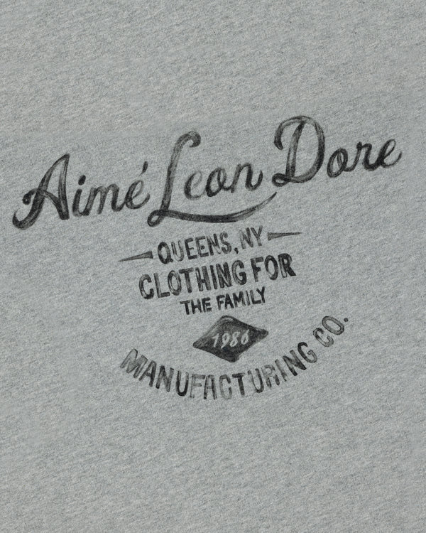 Gray General Store Pocket Tee with "Aimé Leon Dore Queens, NY Clothing for the Family 1980 Manufacturing Co." in black text.