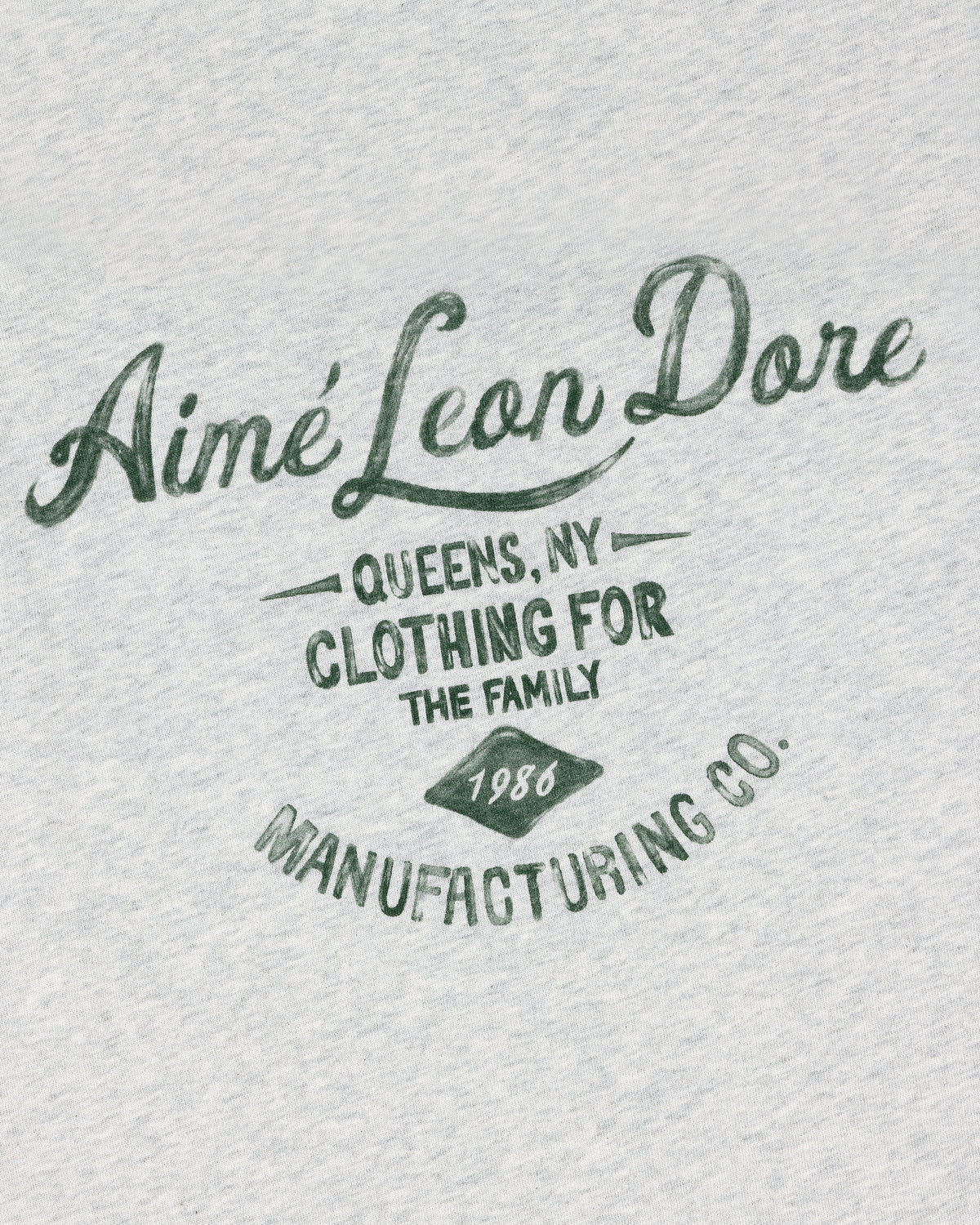 Gray General Store Pocket Tee with green “Aimé Leon Dore, Queens NY, Clothing for the Family, 1986, Manufacturing Co.”.
