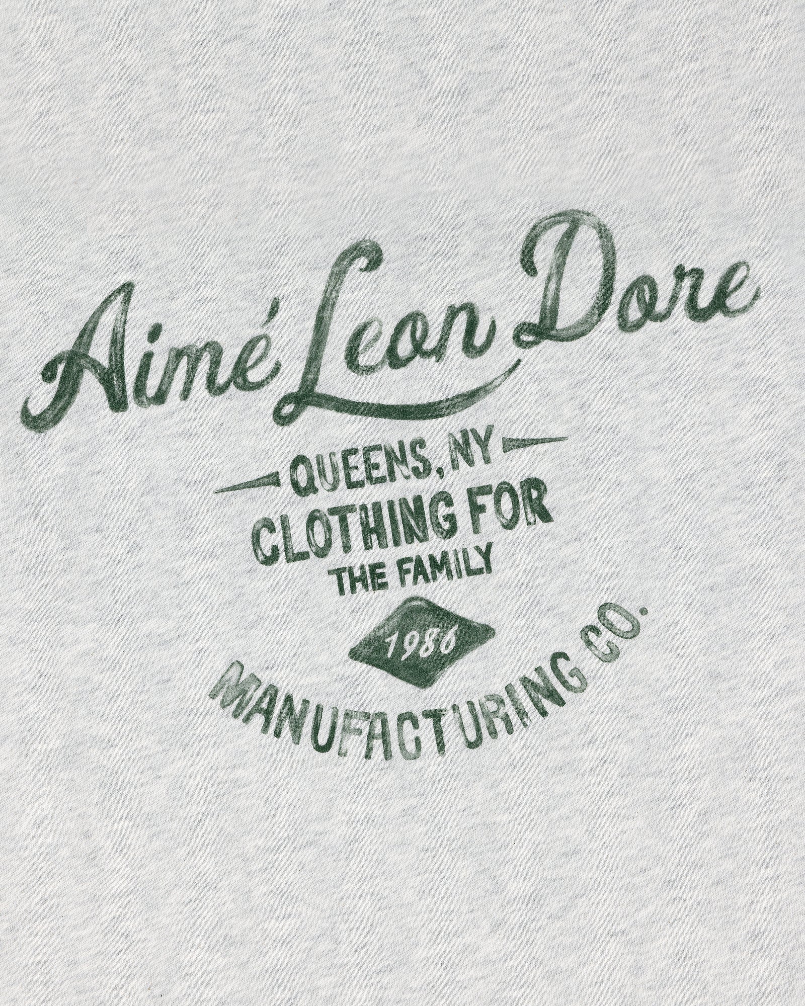Gray General Store Pocket Tee with green “Aimé Leon Dore, Queens NY, Clothing for the Family, 1986, Manufacturing Co.”.