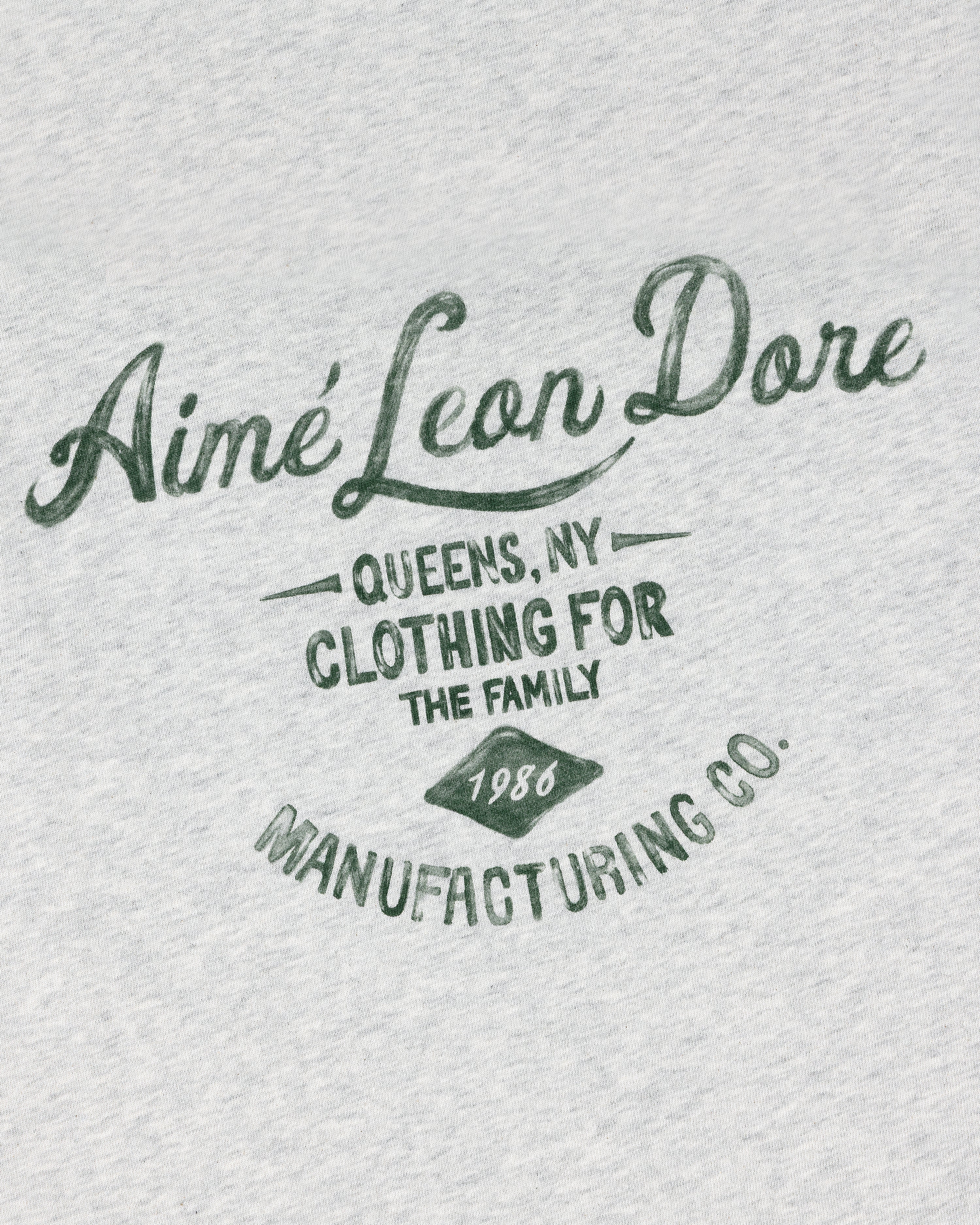 Gray General Store Pocket Tee with green “Aimé Leon Dore, Queens NY, Clothing for the Family, 1986, Manufacturing Co.”.
