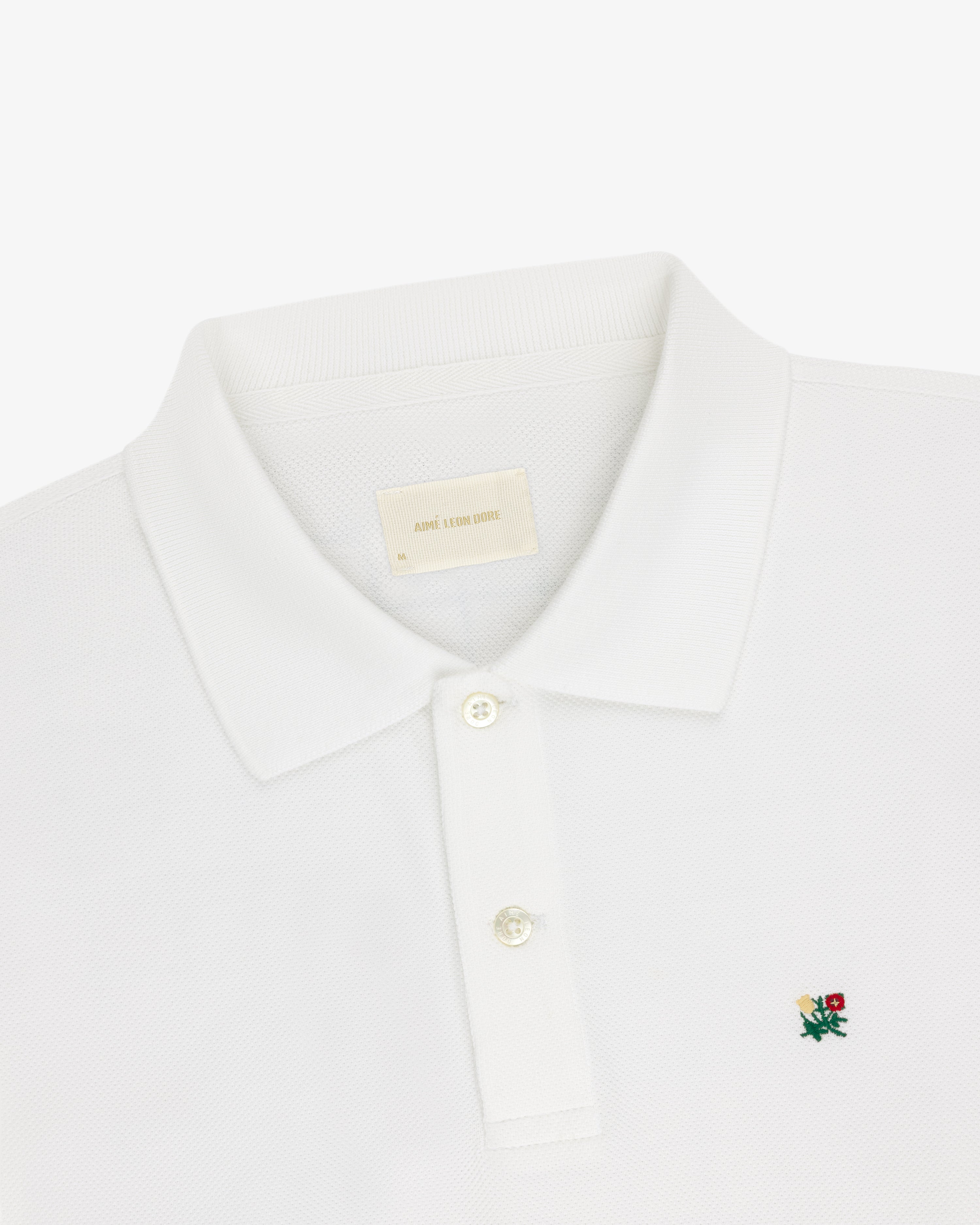 White Long-Sleeve Crest Piqué Polo with a collar, two buttons, and small embroidered rose logo on chest.