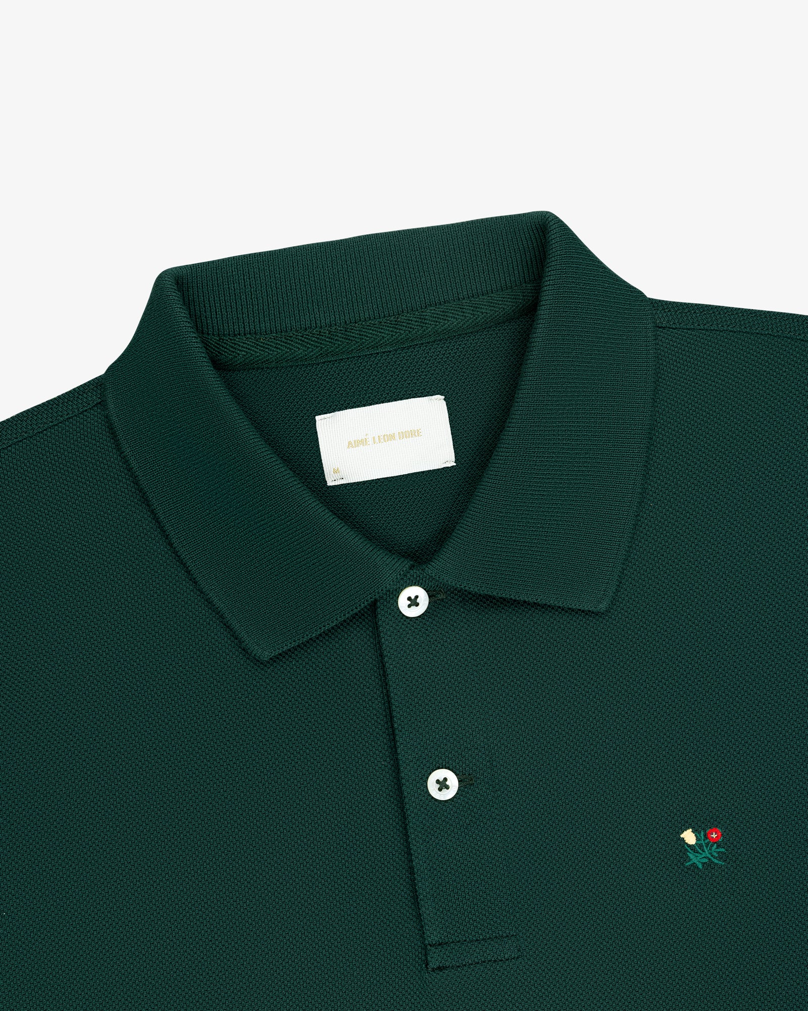 Long-Sleeve Crest Piqué Polo in dark green features a small chest flower and a white inner collar label.