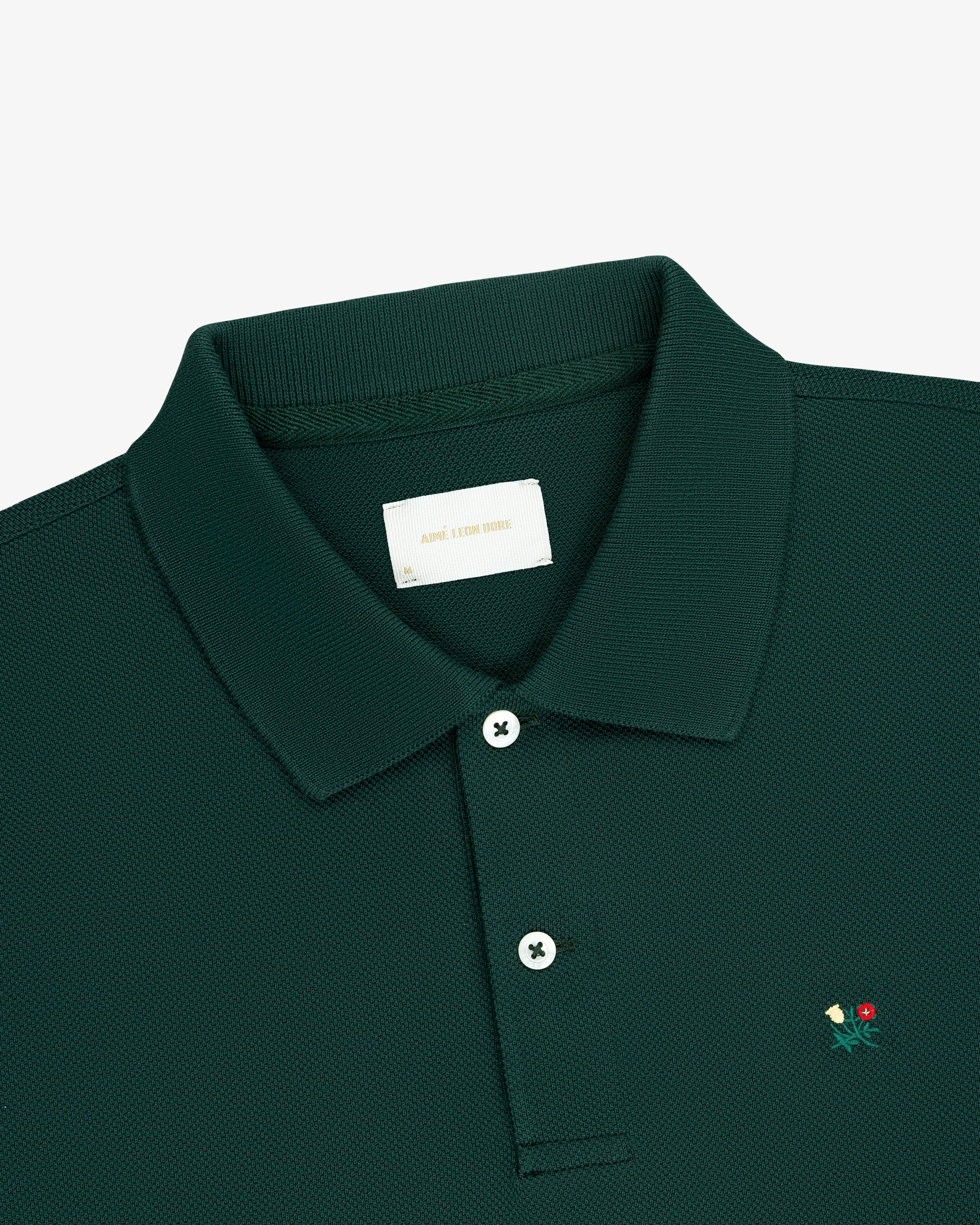 Long-Sleeve Crest Piqué Polo in dark green features a small chest flower and a white inner collar label.