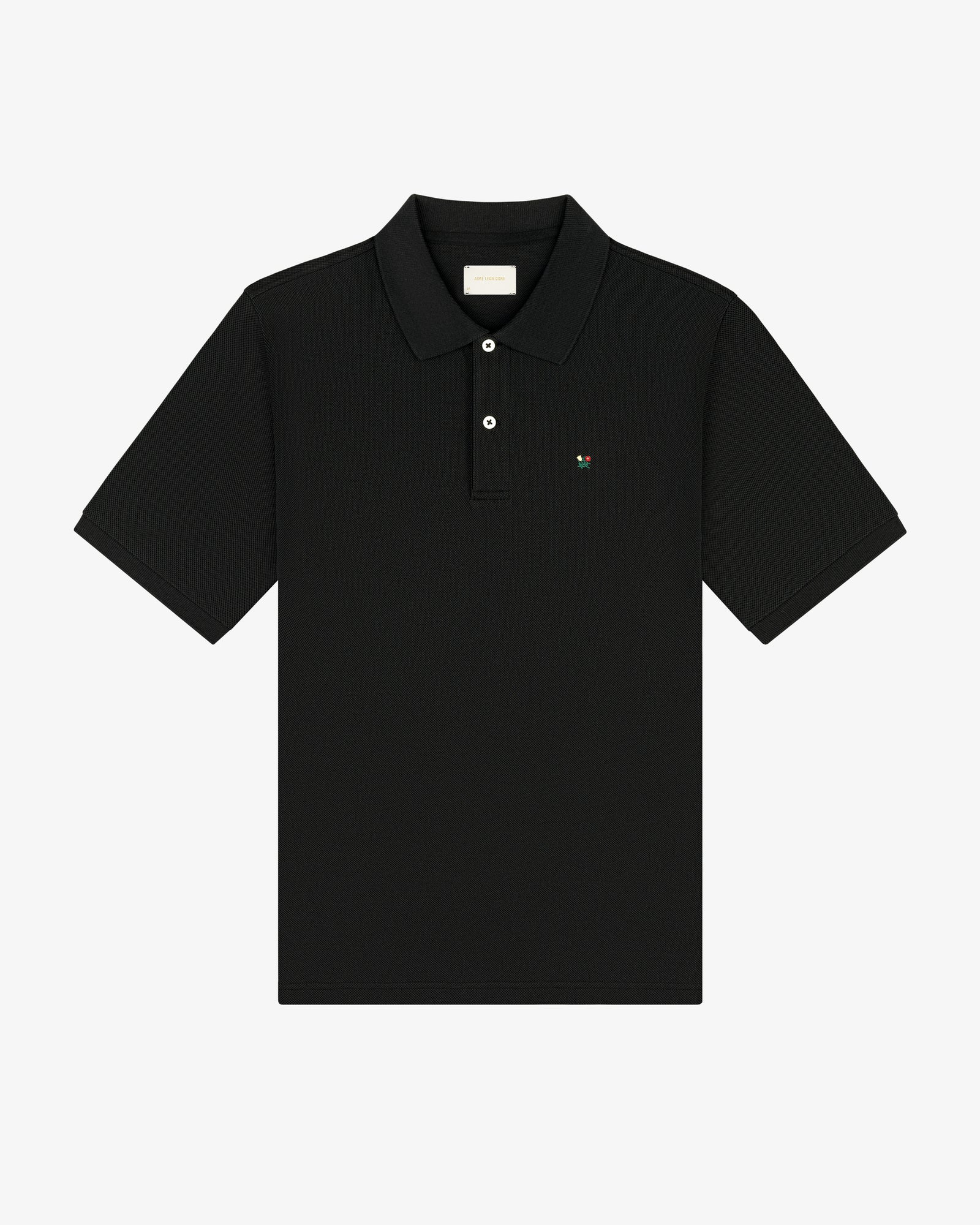 Crest Piqué Polo—black short-sleeve shirt with collar, button placket, and small chest logo.