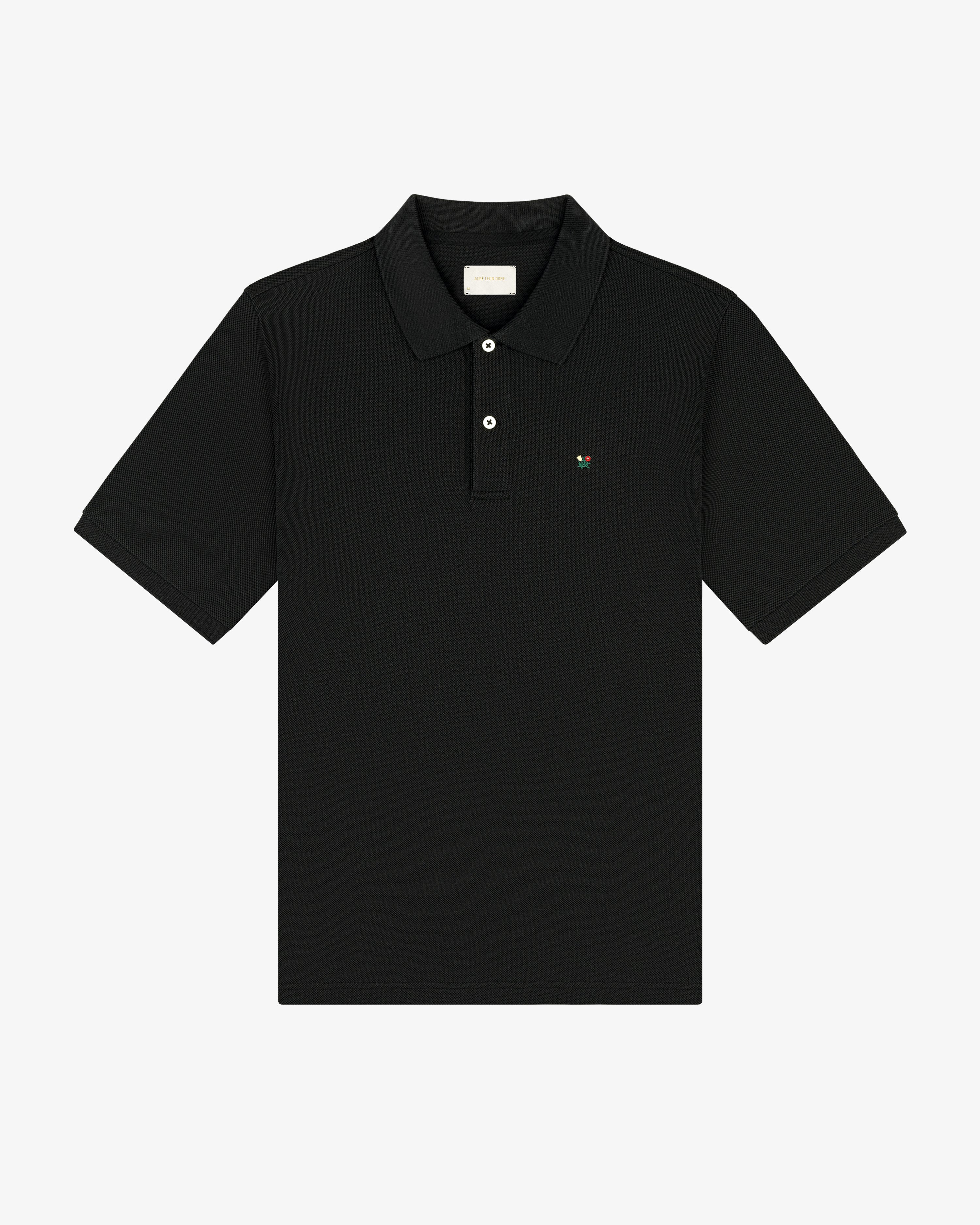 Crest Piqué Polo—black short-sleeve shirt with collar, button placket, and small chest logo.
