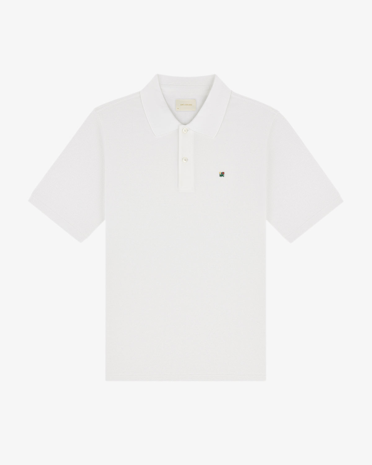 The Crest Piqué Polo is a white short-sleeve shirt with a collar and small embroidered logo on the left chest.
