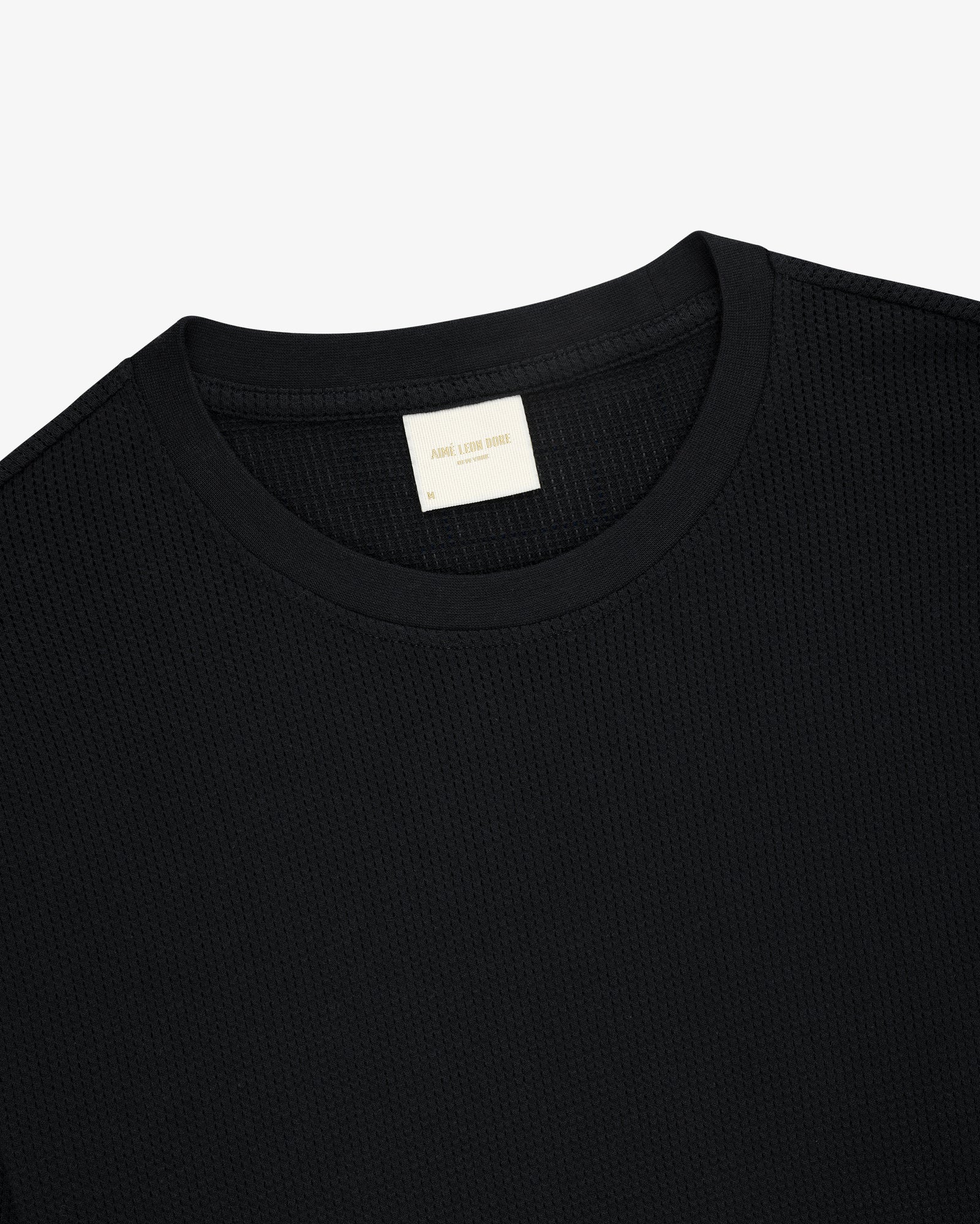 Black Long-Sleeve Mesh Moto Tee with beige neck label, displayed on a plain white background.