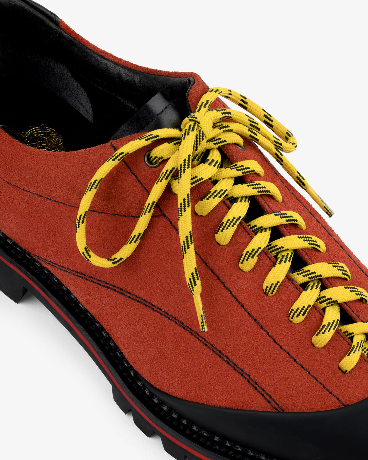Close-up of the Suede Derby Hiker: orange suede, yellow & black laces, and black sole and lining details.