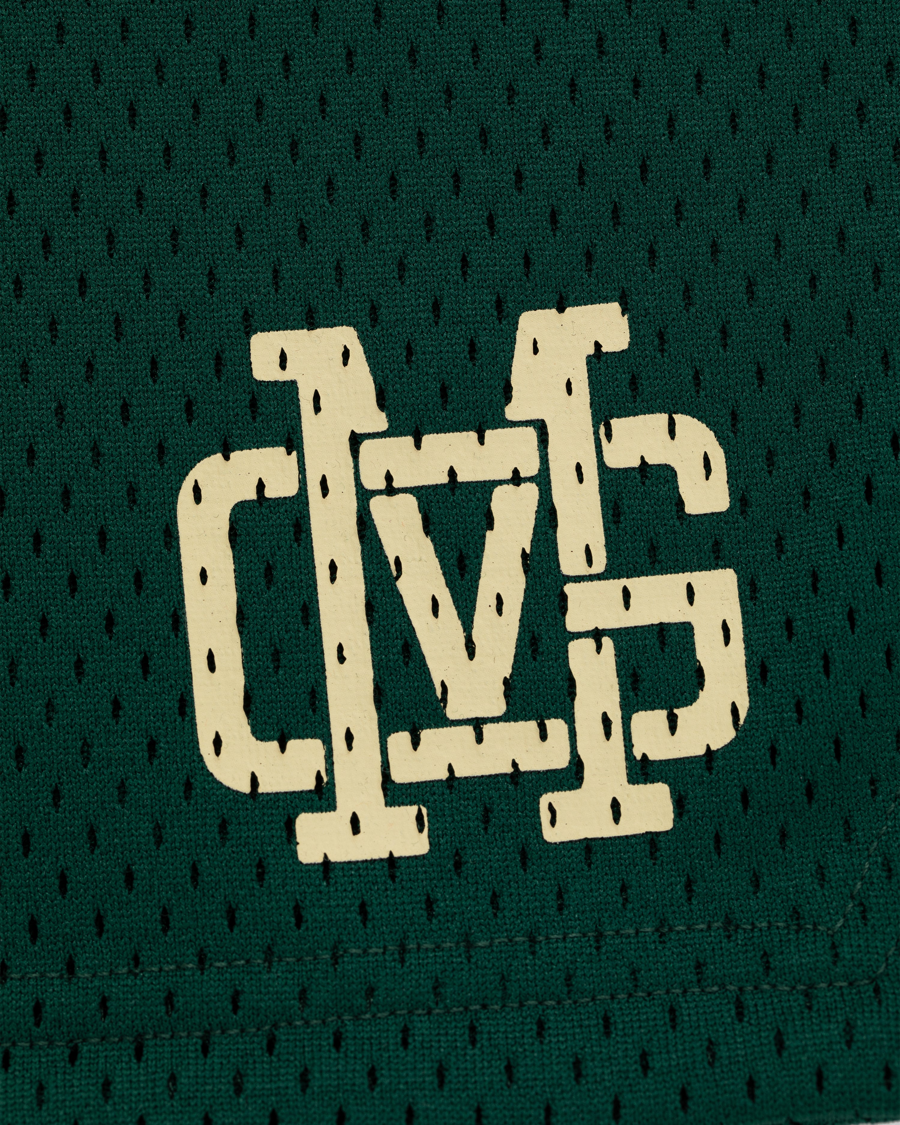 ALD / New Balance SONNY NY Gym Short features a white stylized DVS logo on green mesh fabric with small holes.