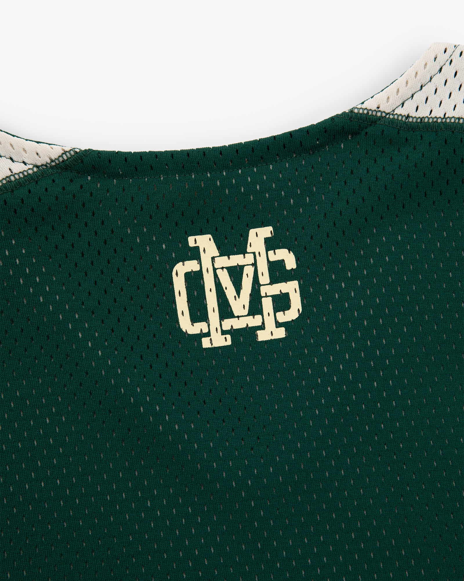 Close-up of an ALD / New Balance SONNY NY Reversible Jersey showing a cream DVS logo on the green mesh collar.
