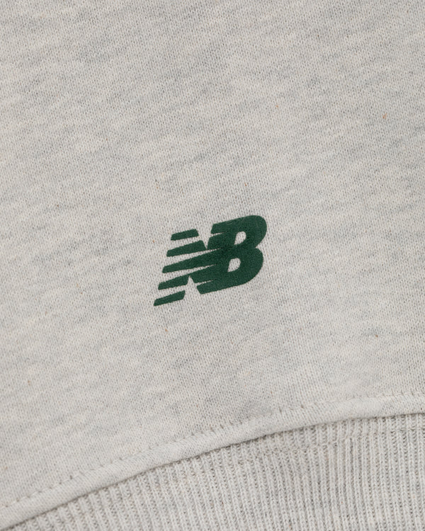 Close-up of a green New Balance logo on light grey ALD / New Balance SONNY NY IFTB Crewneck Sweatshirt.