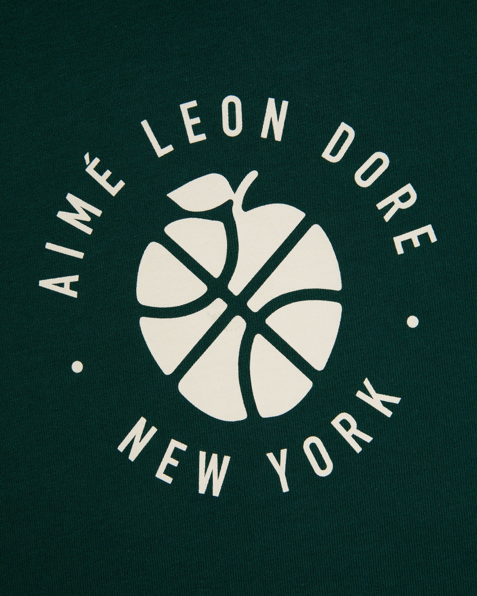White basketball-apple logo and "AIMÉ LEON DORE NEW YORK" on dark green ALD / New Balance SONNY NY Long-Sleeve Tee.