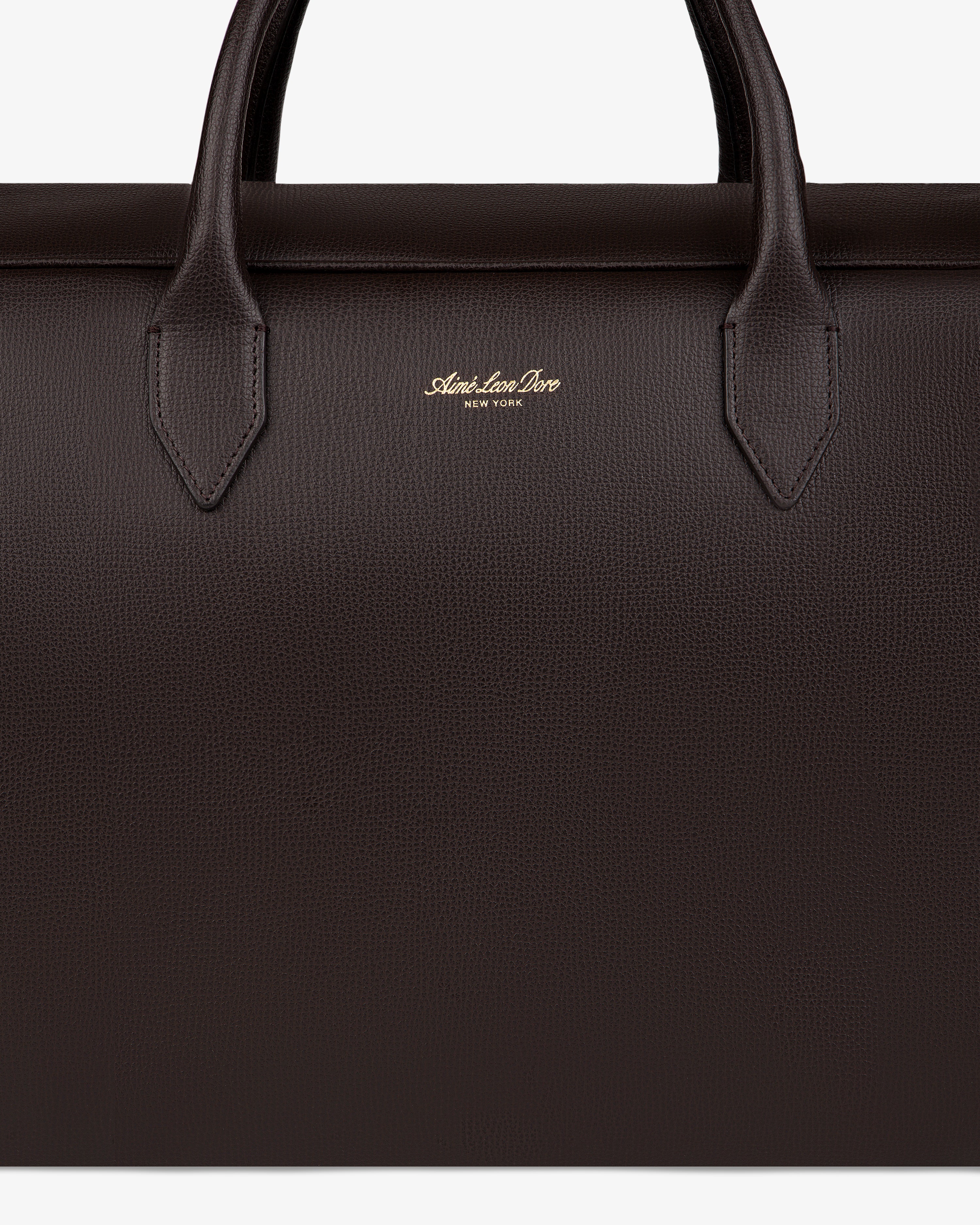 Close-up of a dark brown Full Grain Leather Briefcase Duffle with two handles and gold Mark Cross New York logo.