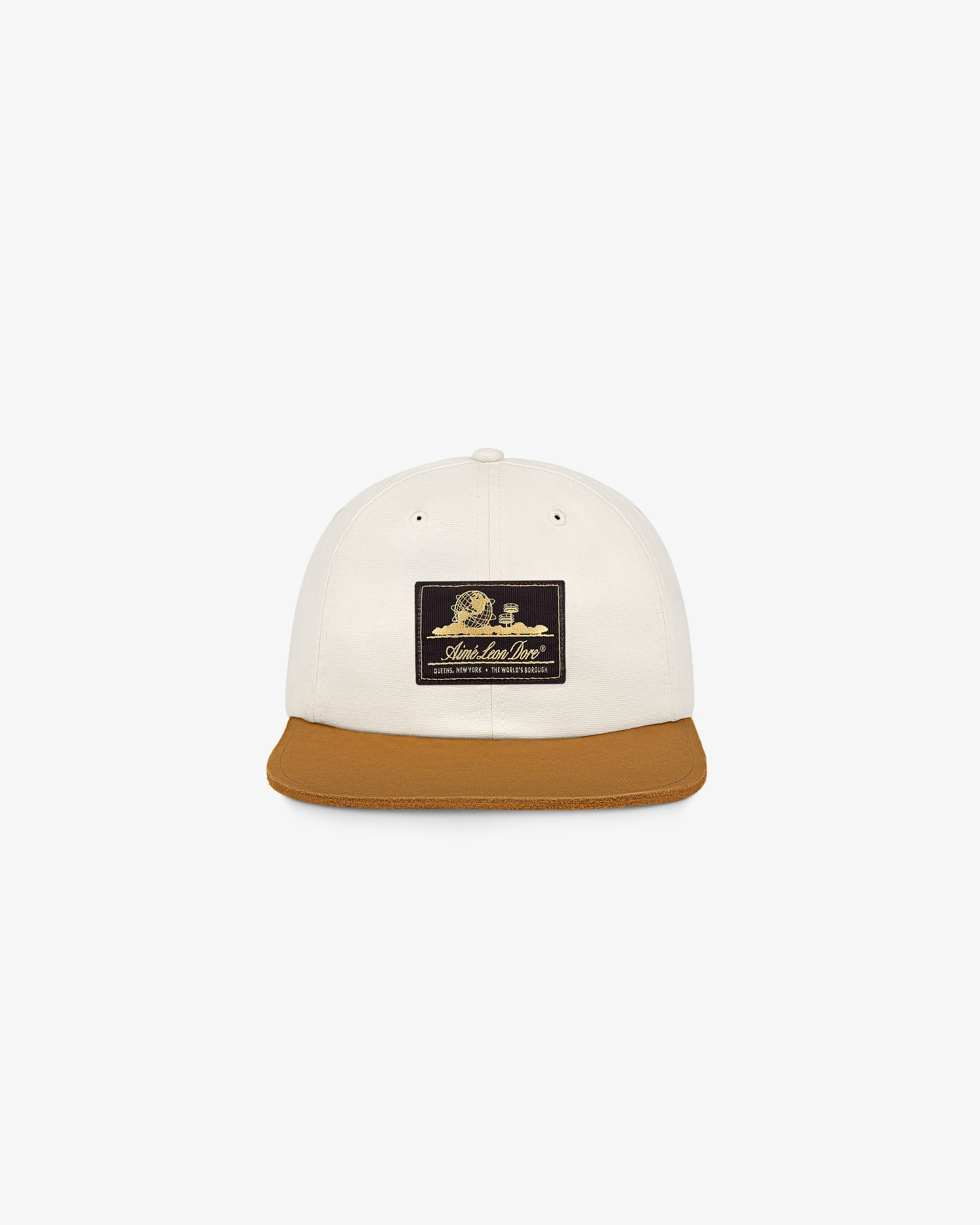 Unisphere Label Hat: White cap, brown brim, black front patch with gold text and a small graphic.