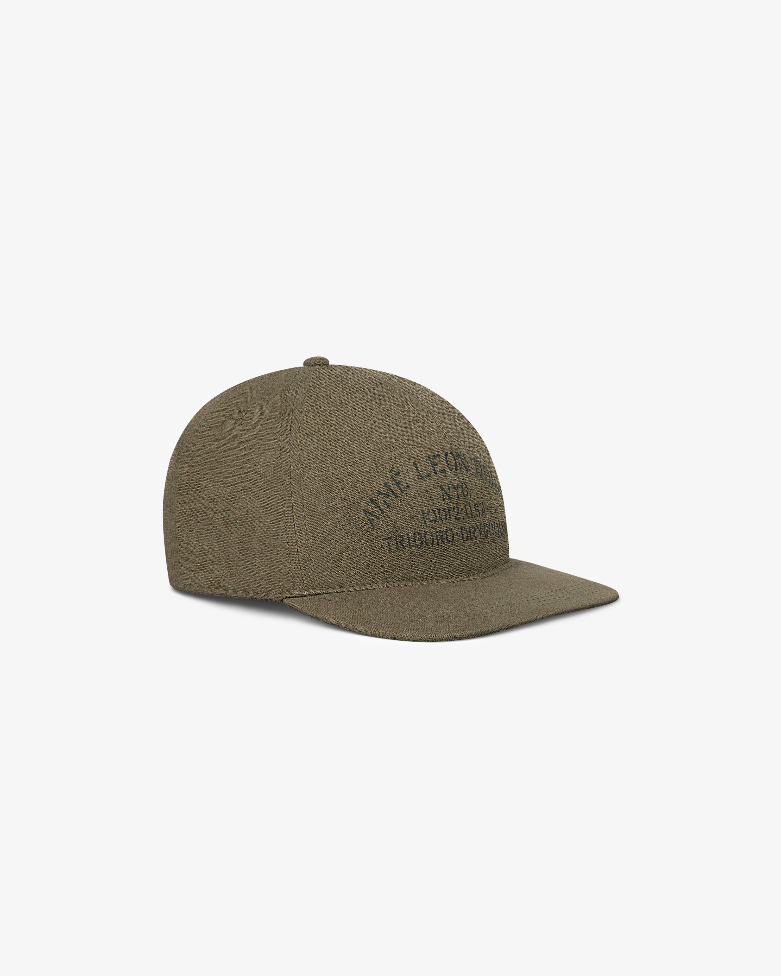 Triborough Dry Goods Hat in olive green with curved brim and subtle black embroidery, shown from an angled view.
