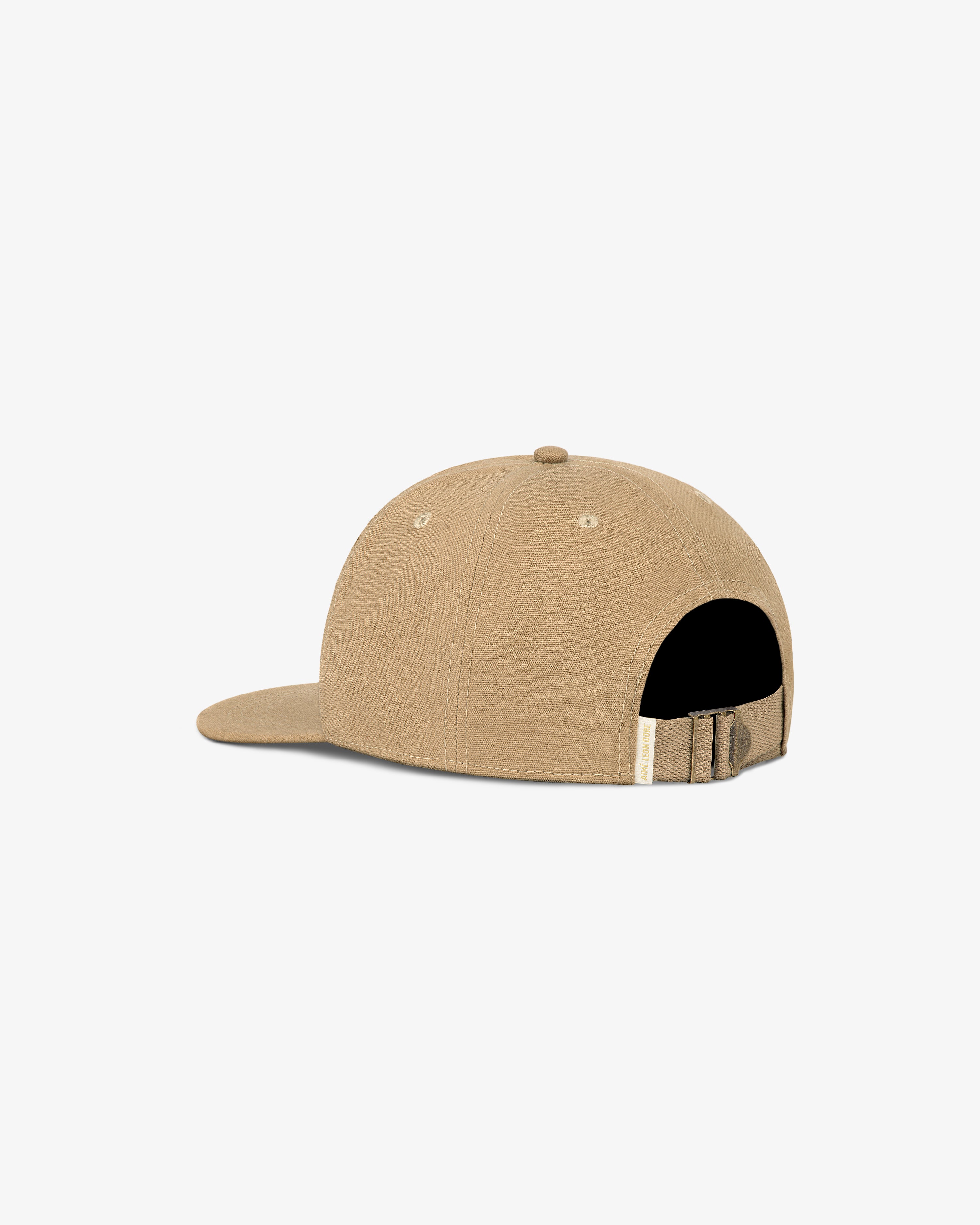 Triborough Dry Goods Hat in tan, back view with adjustable strap and metal clasp on white background.
