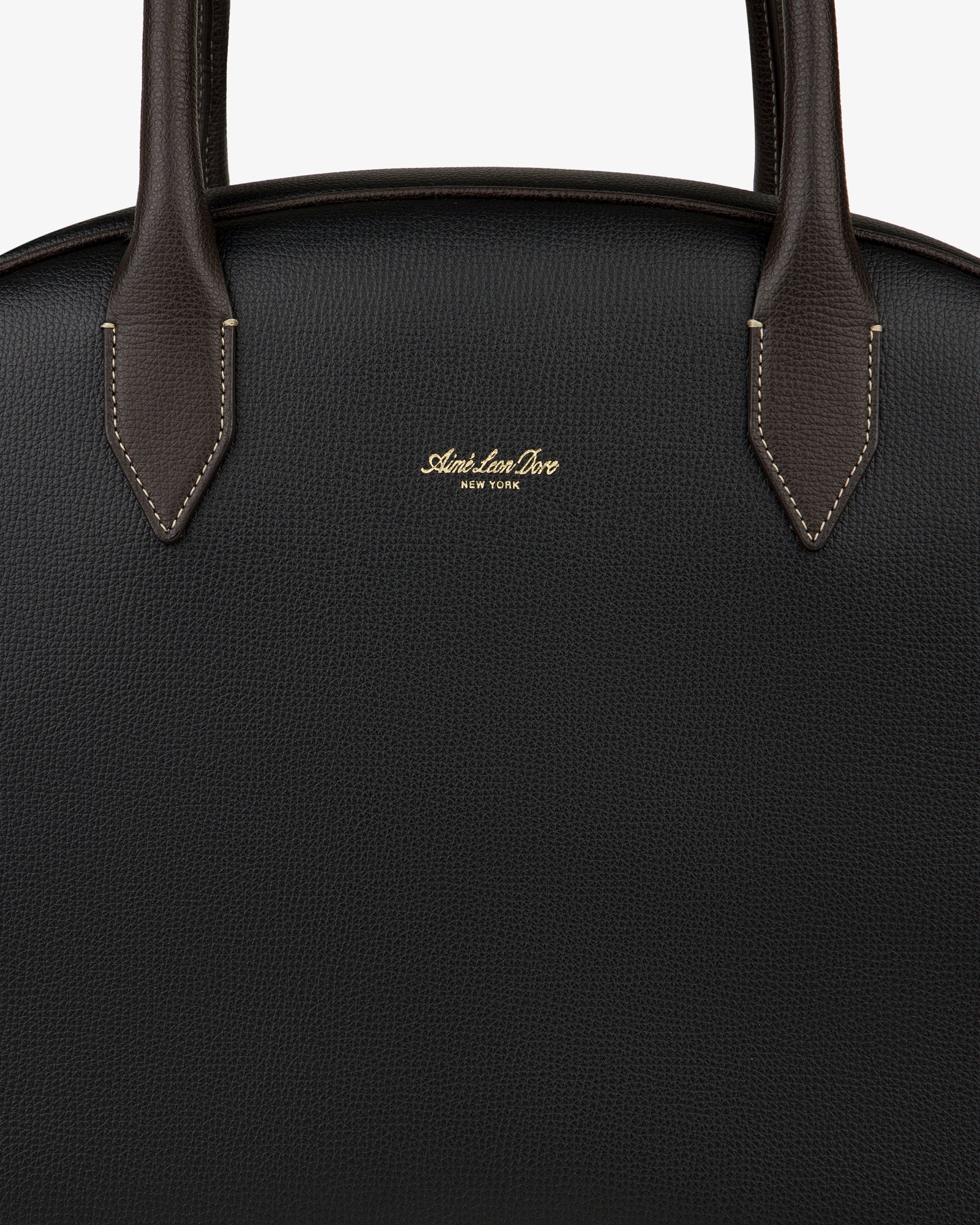 Close-up of a black Full Grain Leather Crescent Shoulder Bag with brown handles and gold Sloan & Sons, New York branding.