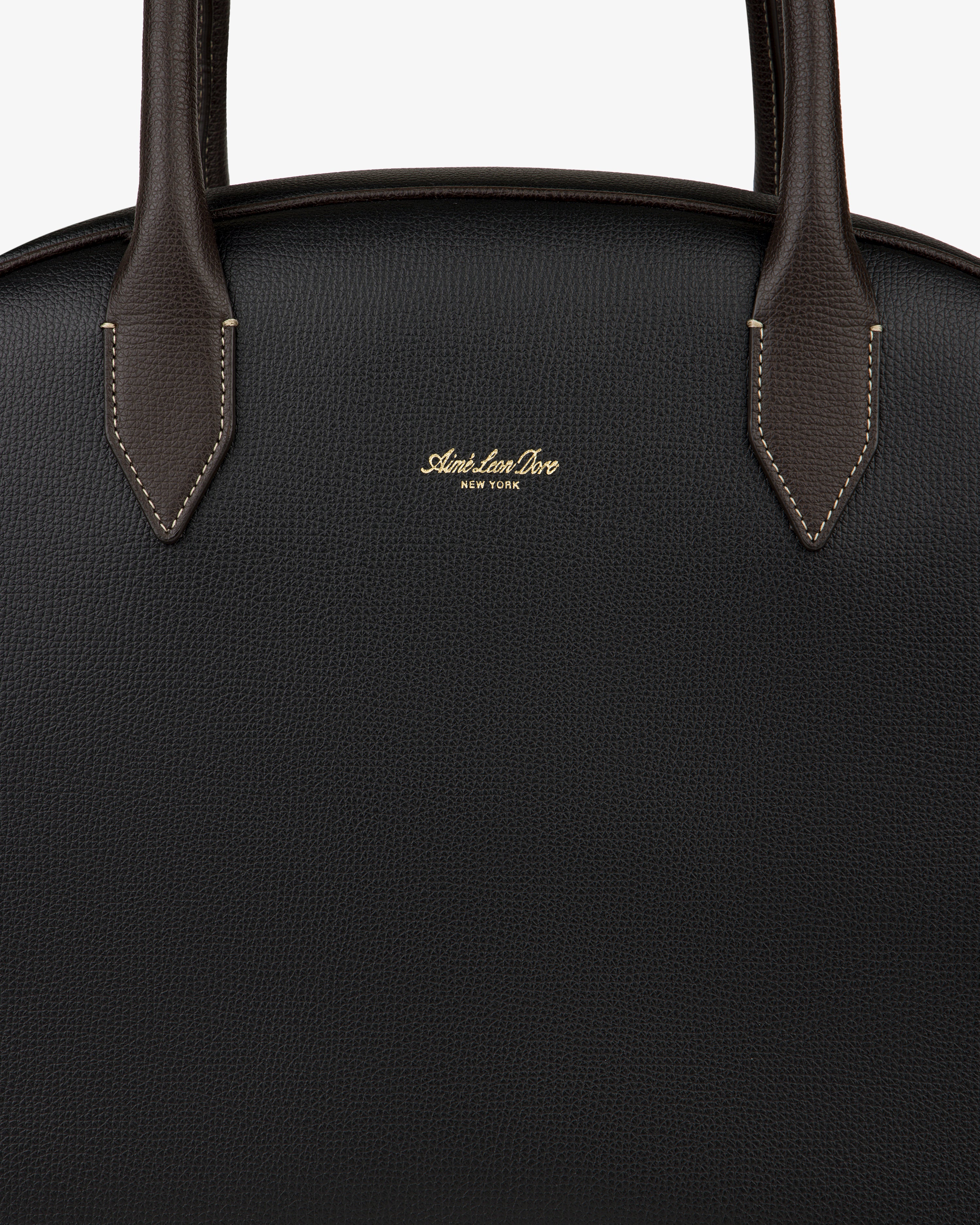 Close-up of a black Full Grain Leather Crescent Shoulder Bag with brown handles and gold Sloan & Sons, New York branding.