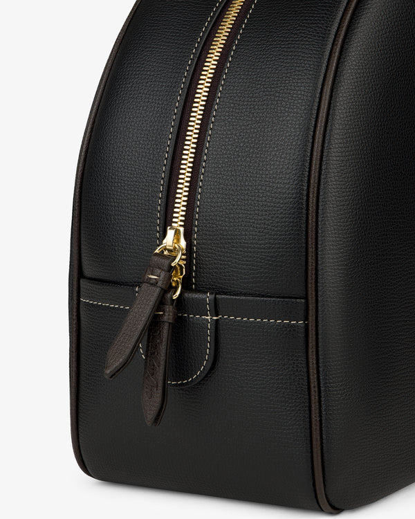 Close-up of the Full Grain Leather Crescent Shoulder Bag in black with gold zipper, brown pull tabs, and white stitching.