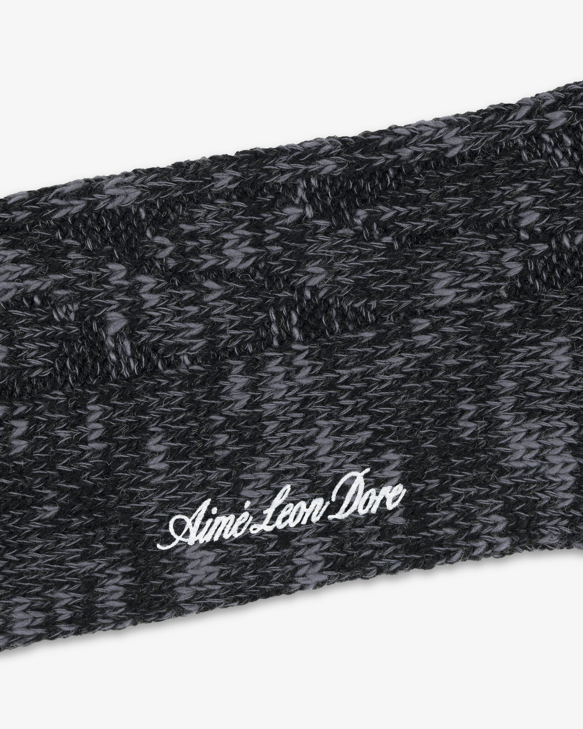 Close-up of a black and gray Cable Knit Hiking Sock with Aime Leon Dore embroidered in white script.
