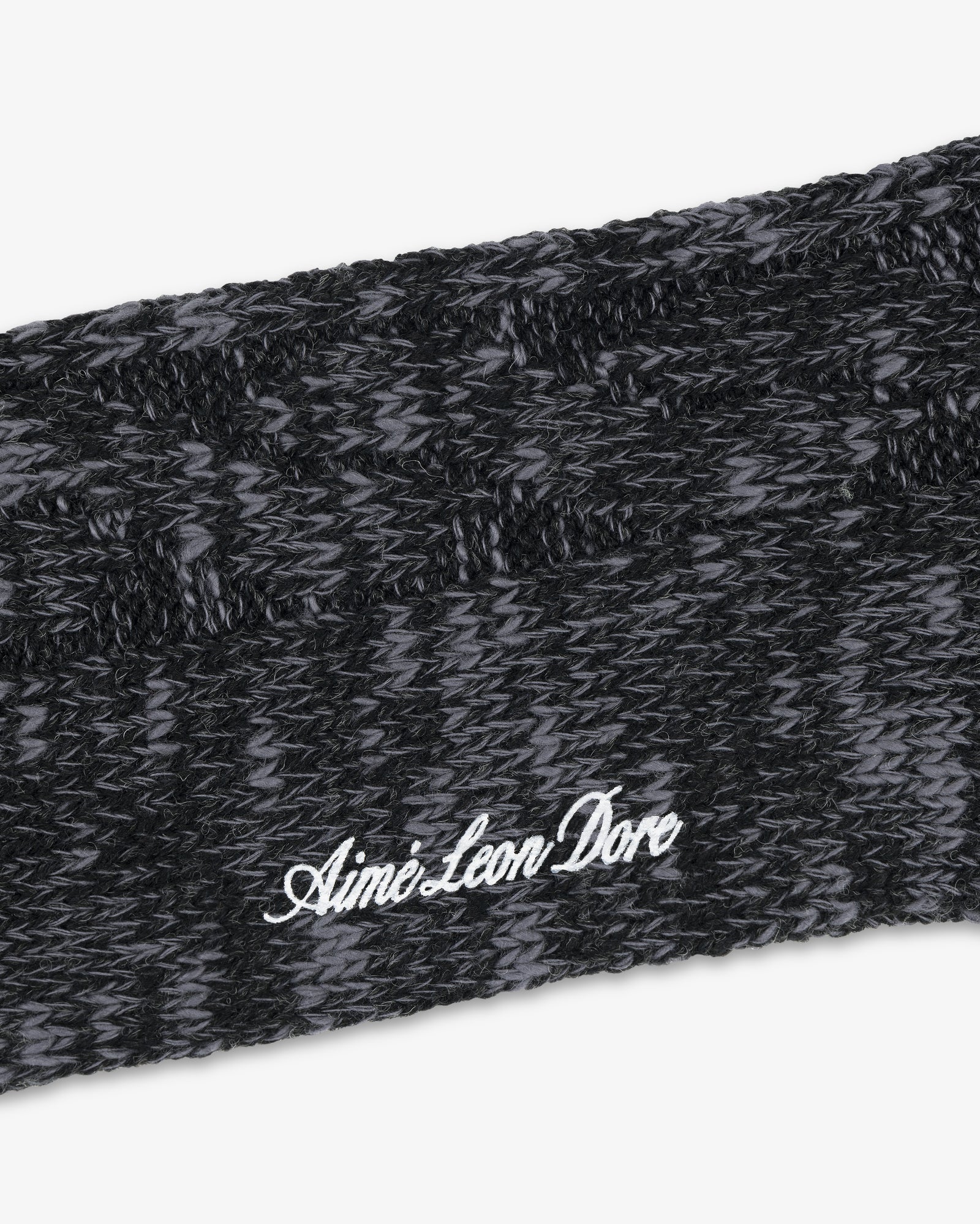 Close-up of a black and gray Cable Knit Hiking Sock with Aime Leon Dore embroidered in white script.