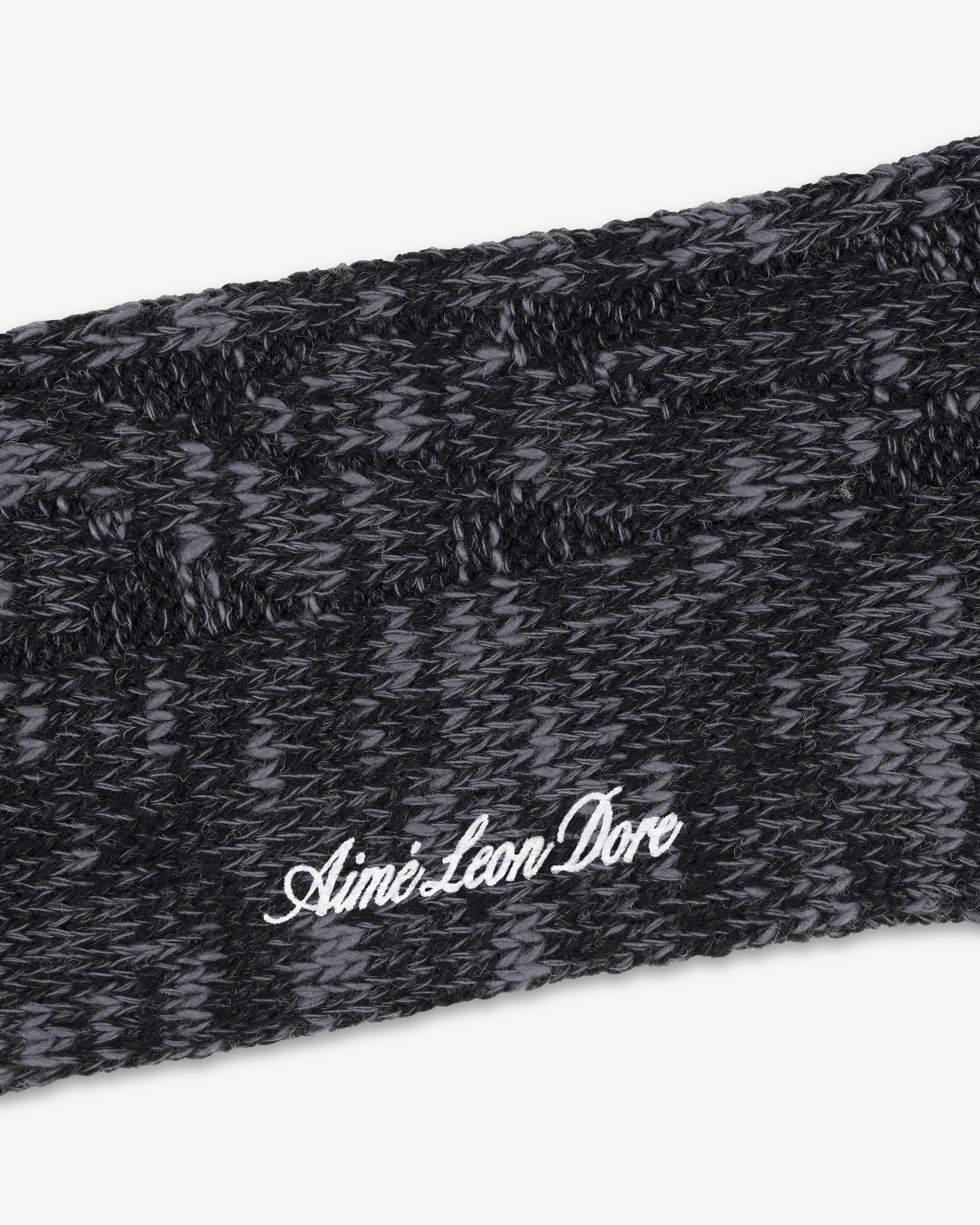 Close-up of a black and gray Cable Knit Hiking Sock with Aime Leon Dore embroidered in white script.