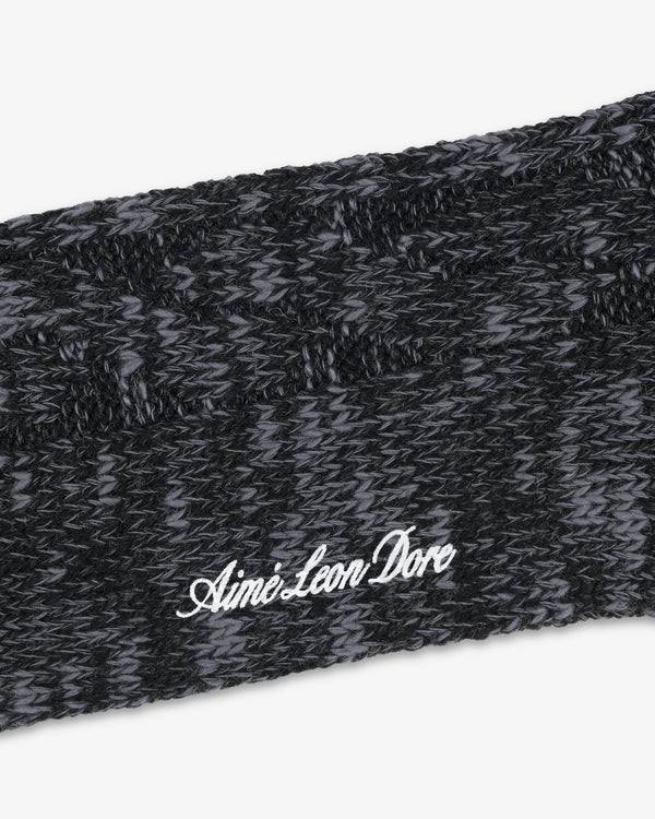 Close-up of a black and gray Cable Knit Hiking Sock with Aime Leon Dore embroidered in white script.