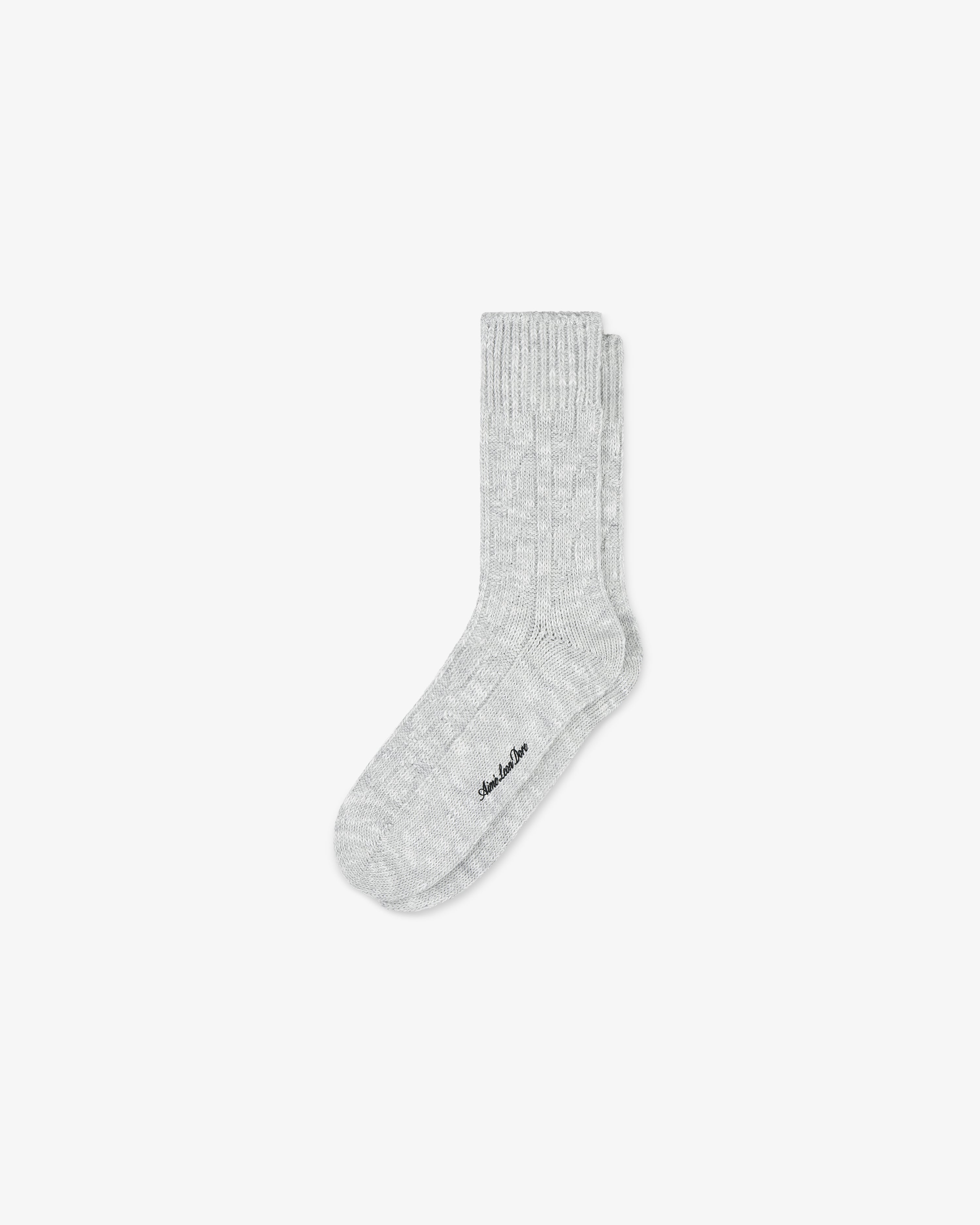 Single cable knit hiking sock in light gray, with subtle texture, laid flat on a plain white background.