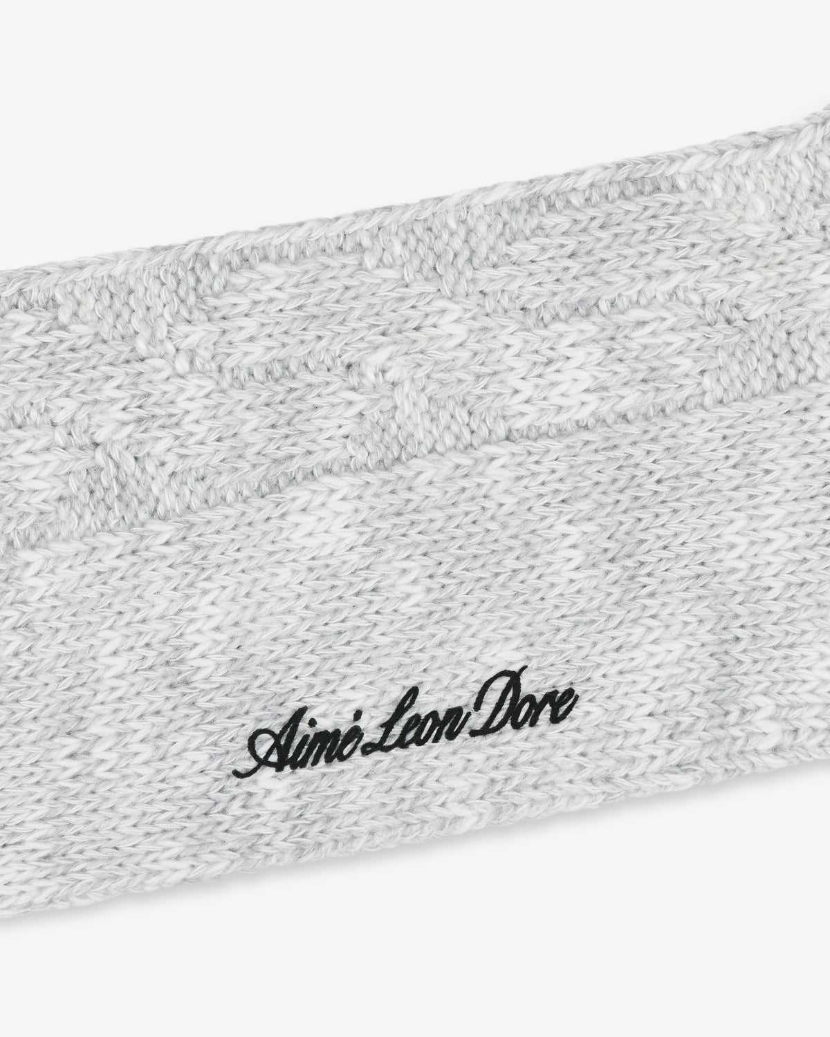 Close-up of a gray Cable Knit Hiking Sock with black Aimé Leon Dore embroidered text.