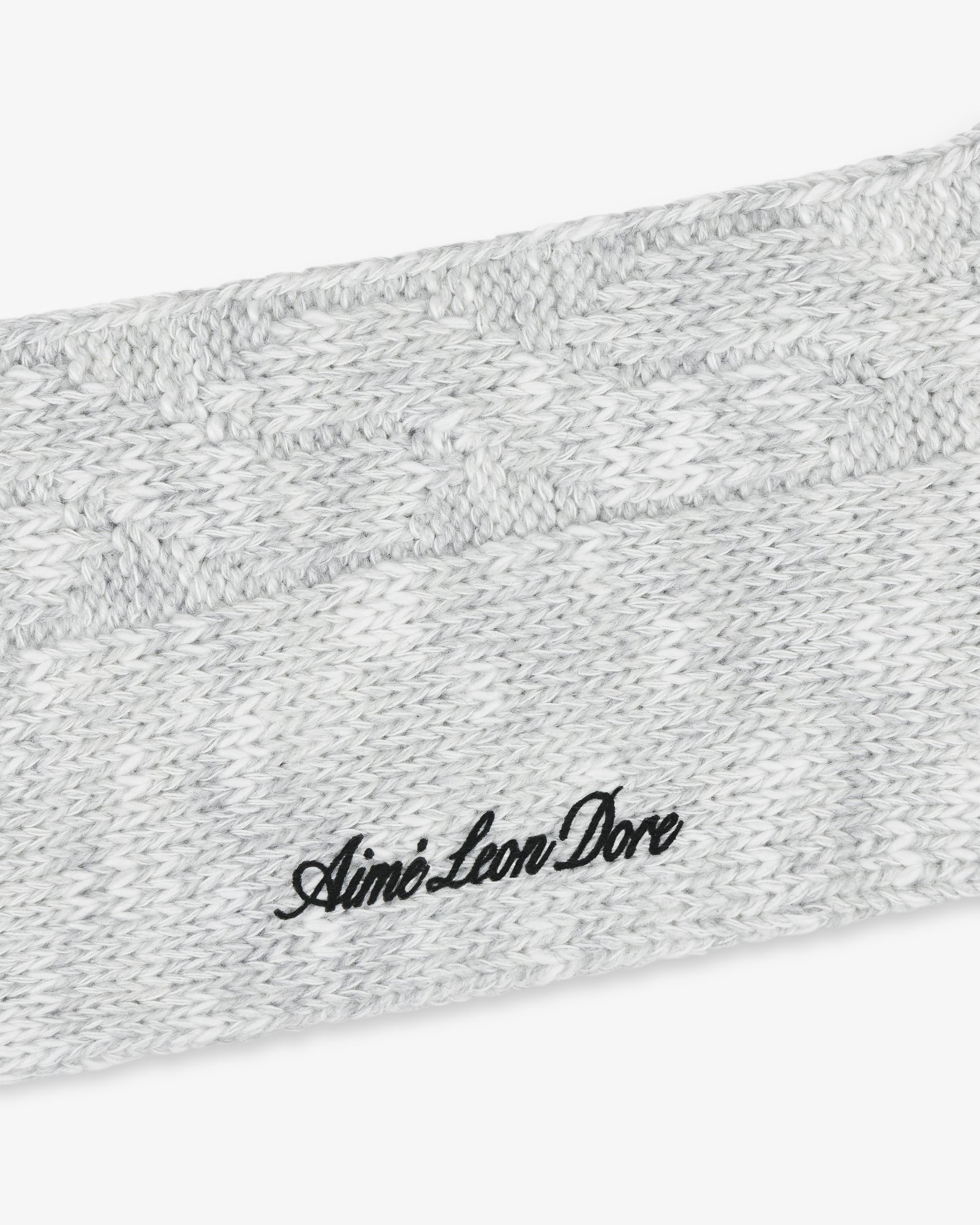 Close-up of a gray Cable Knit Hiking Sock with black Aimé Leon Dore embroidered text.