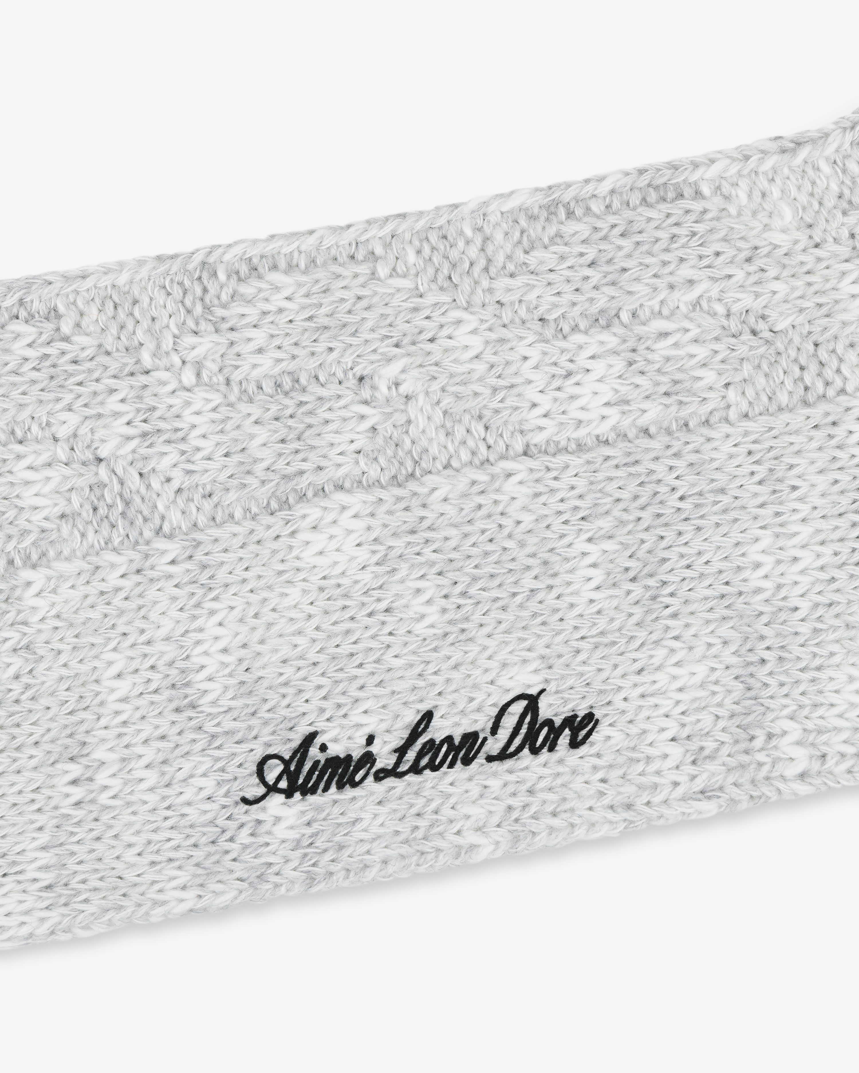 Close-up of a gray Cable Knit Hiking Sock with black Aimé Leon Dore embroidered text.
