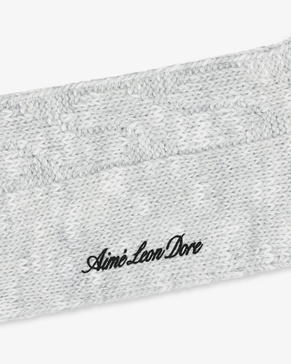 Close-up of a gray Cable Knit Hiking Sock with black Aimé Leon Dore embroidered text.